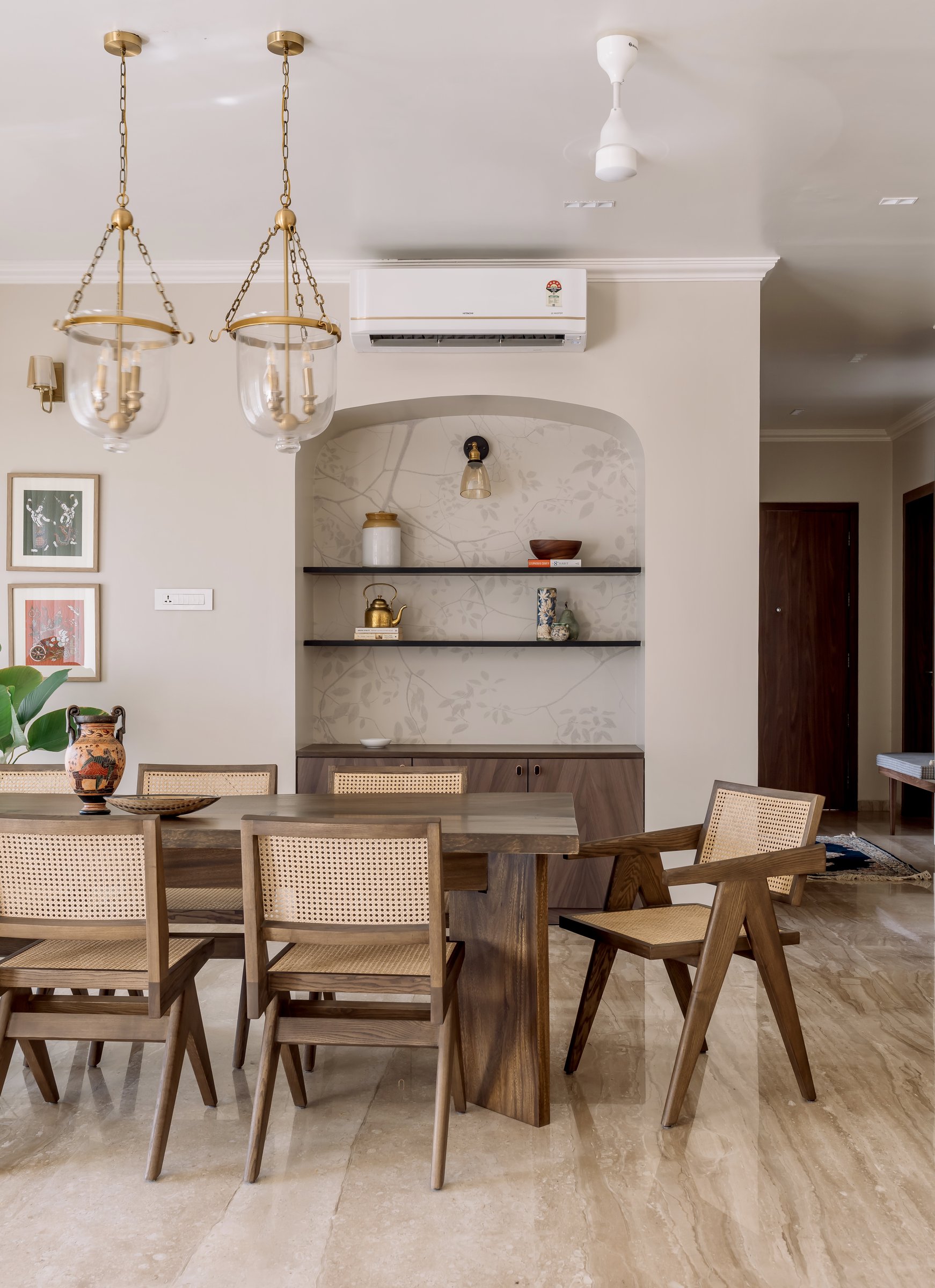 The arched display niche behind the dining table, a contemporary reinterpretation of a traditional wall niche