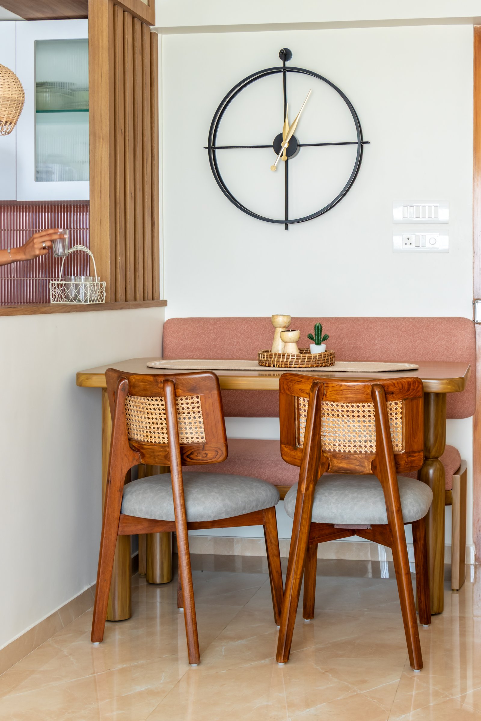 The dining nook: a banquette and two cane-back chairs tucked against the kitchen pass-through