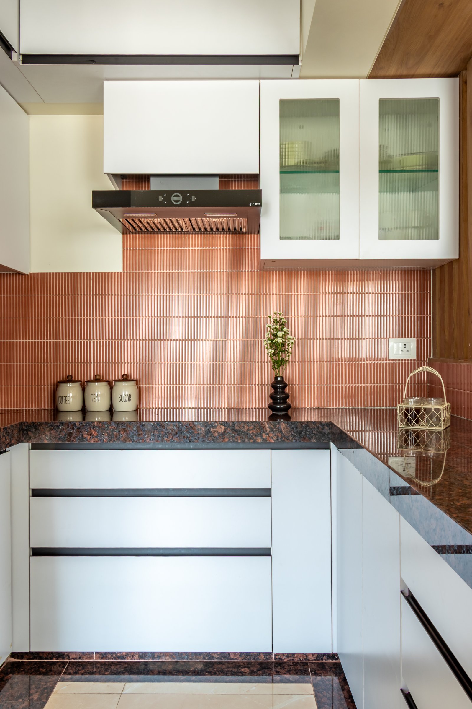 The kitchen's one decision: a ribbed terracotta tile run full height behind the counter