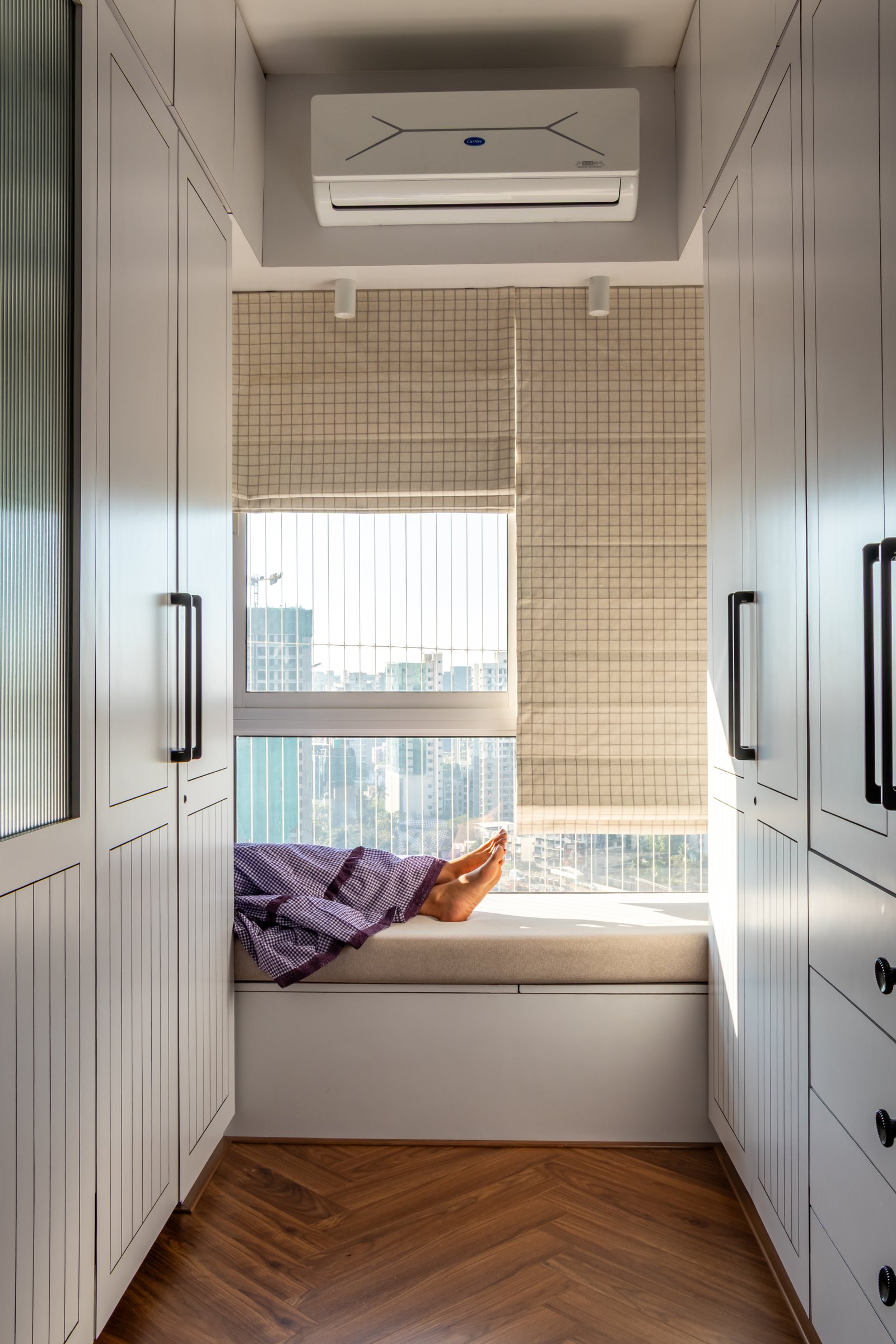The window seat, the home's most generous gesture toward stillness, framing a view across the Borivali skyline