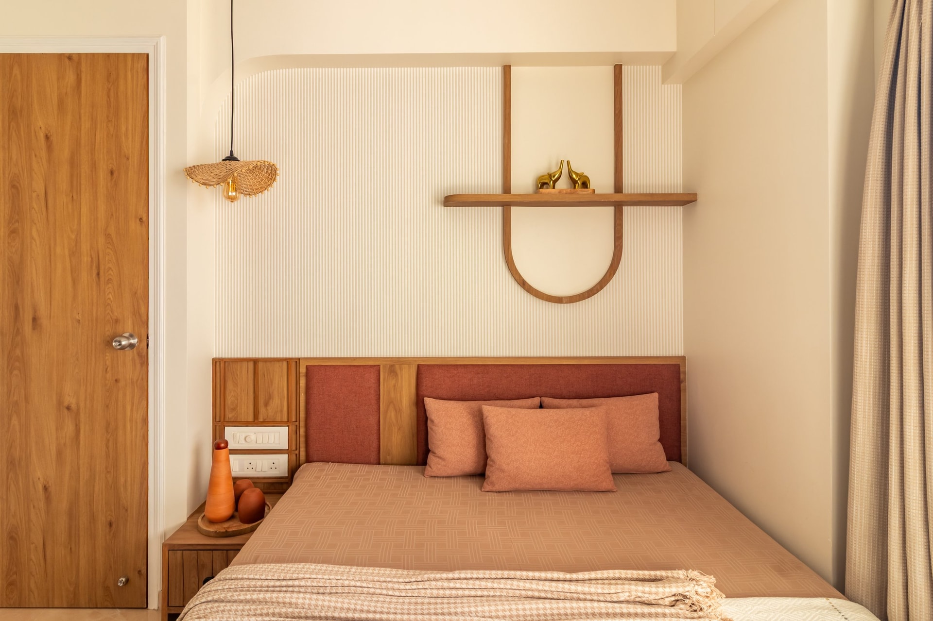The bedroom carries the home's warmest palette, with a fabric-and-wood headboard set against a fluted cream wall