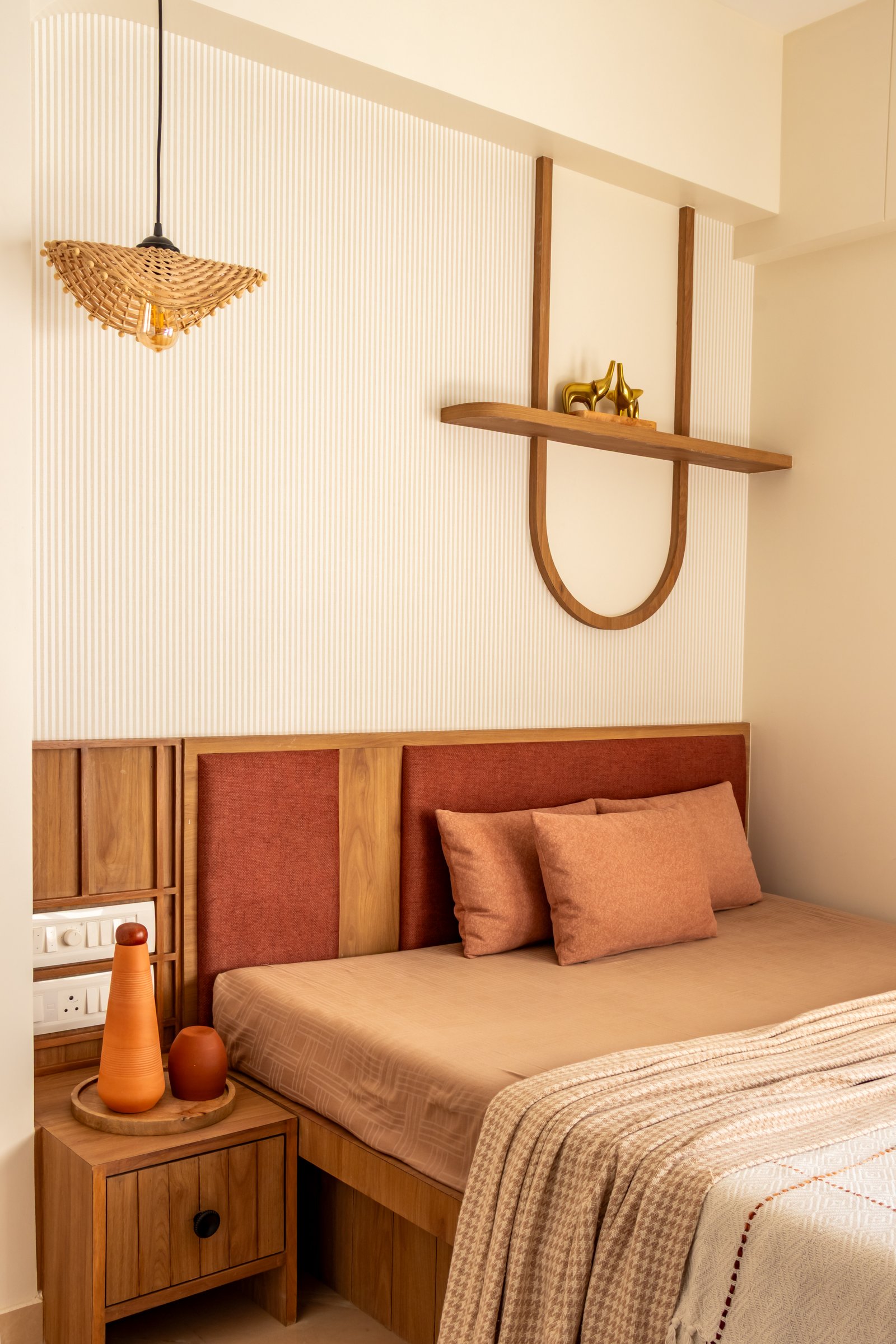 The slim wood arch above the bed echoes the living room's mouldings, binding the apartment into one continuous language