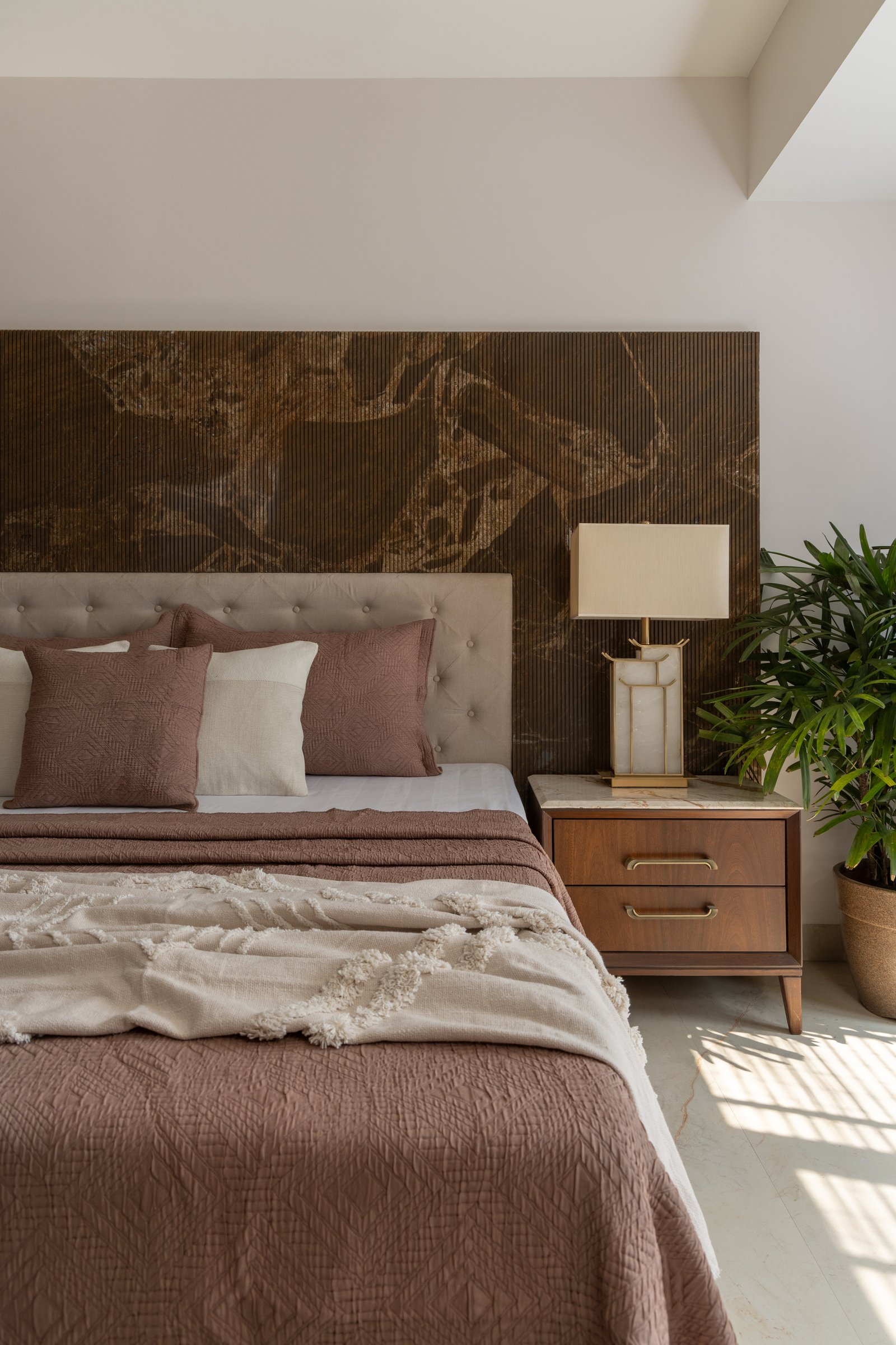 A closer view of the master headboard, where fluting and a bronzed patinated surface share the same plane