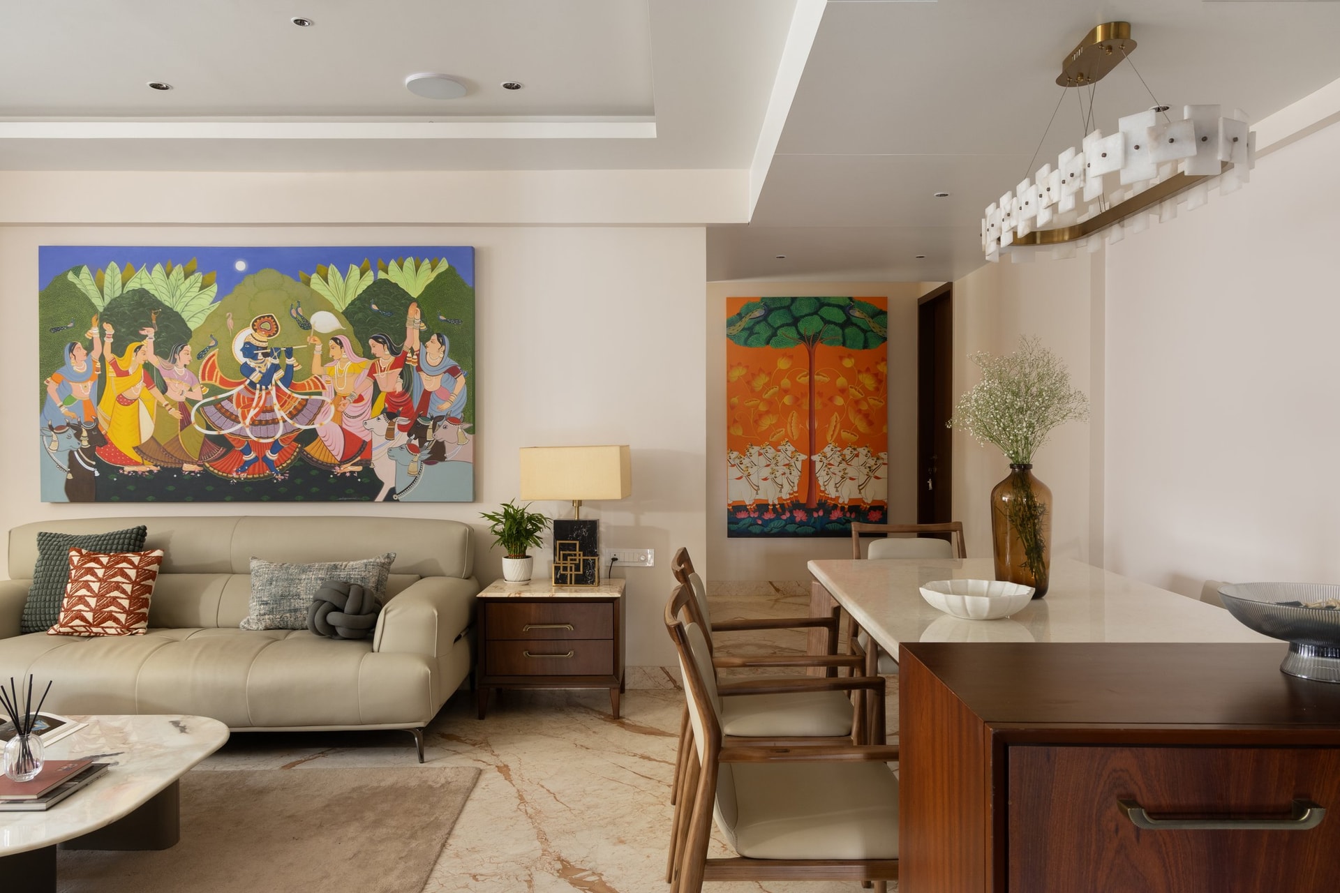 Turning toward the dining area, a second canvas in burnt orange answers the Pichwai across the room
