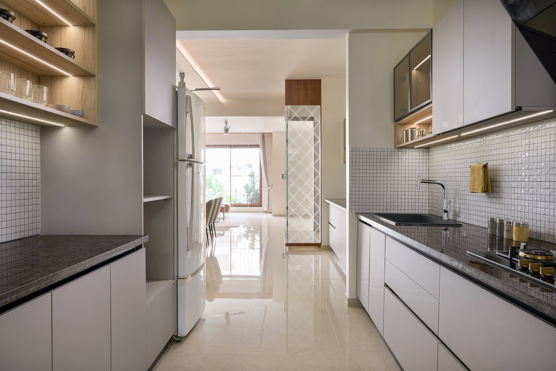 The kitchen reads as a disciplined corridor, framed by the dining room at one end and a diamond-etched utility door at the other