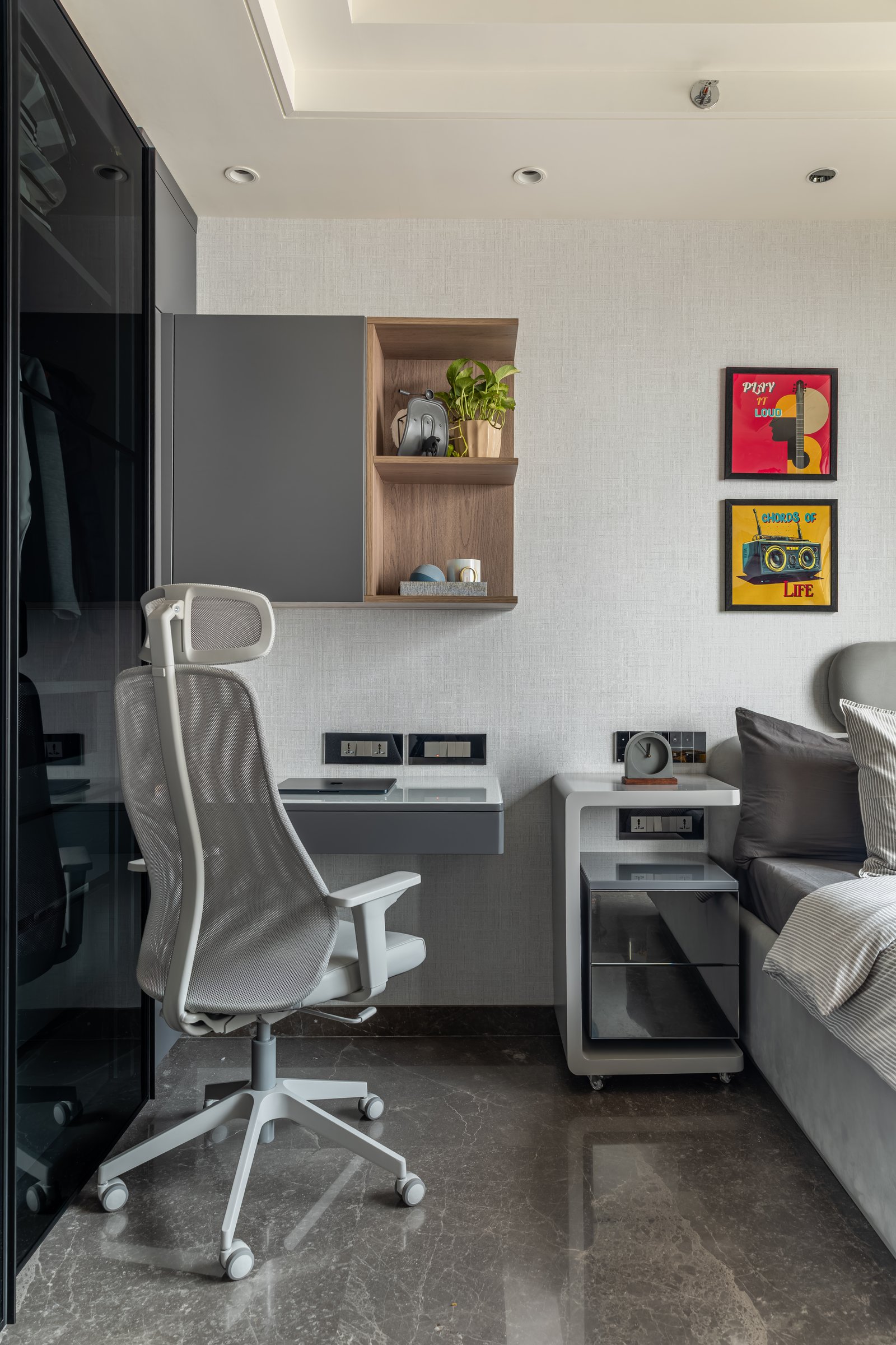 The work nook, with a wall-mounted desk, recessed wood shelf, and ergonomic chair