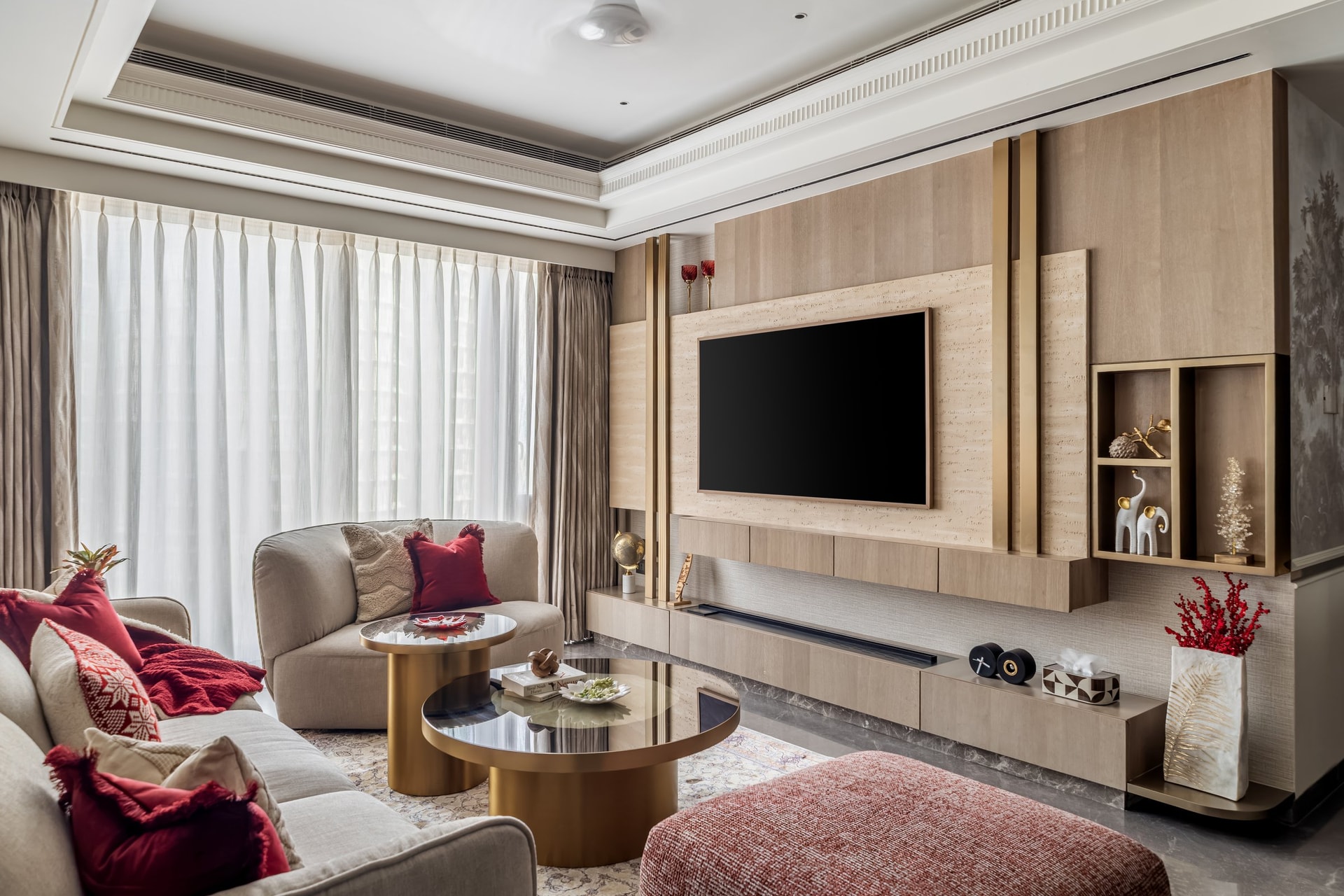 The entertainment wall, integrating television, display, and storage within a single composition of pale wood and brass