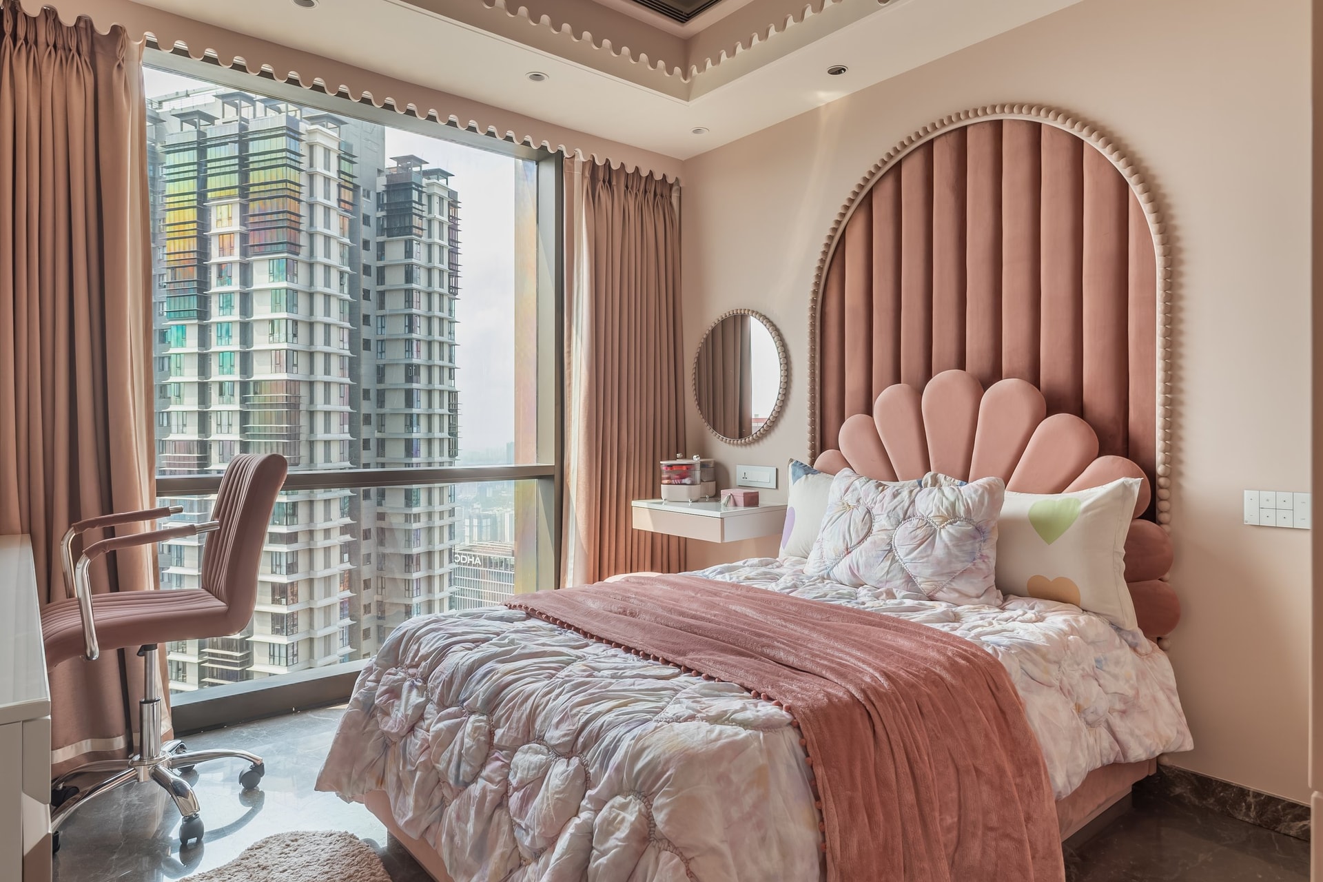 The daughter's bedroom, where a dusty pink scalloped velvet headboard becomes the defining gesture