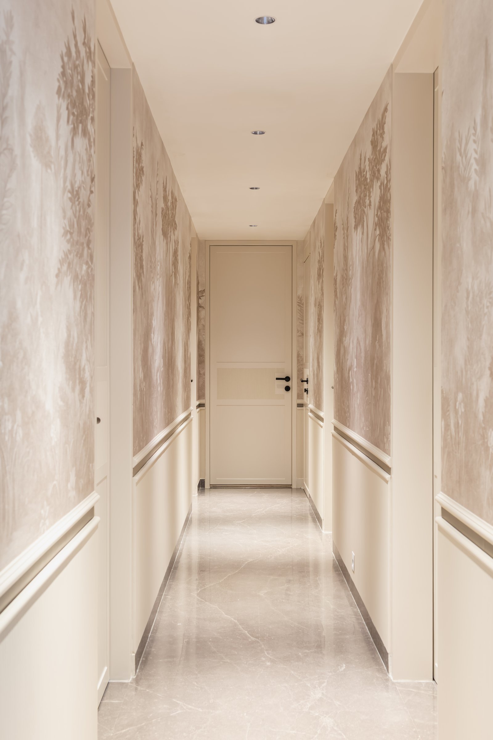 The principal corridor, where wainscoting and a misty silhouette wallcovering turn a passage into an atmosphere