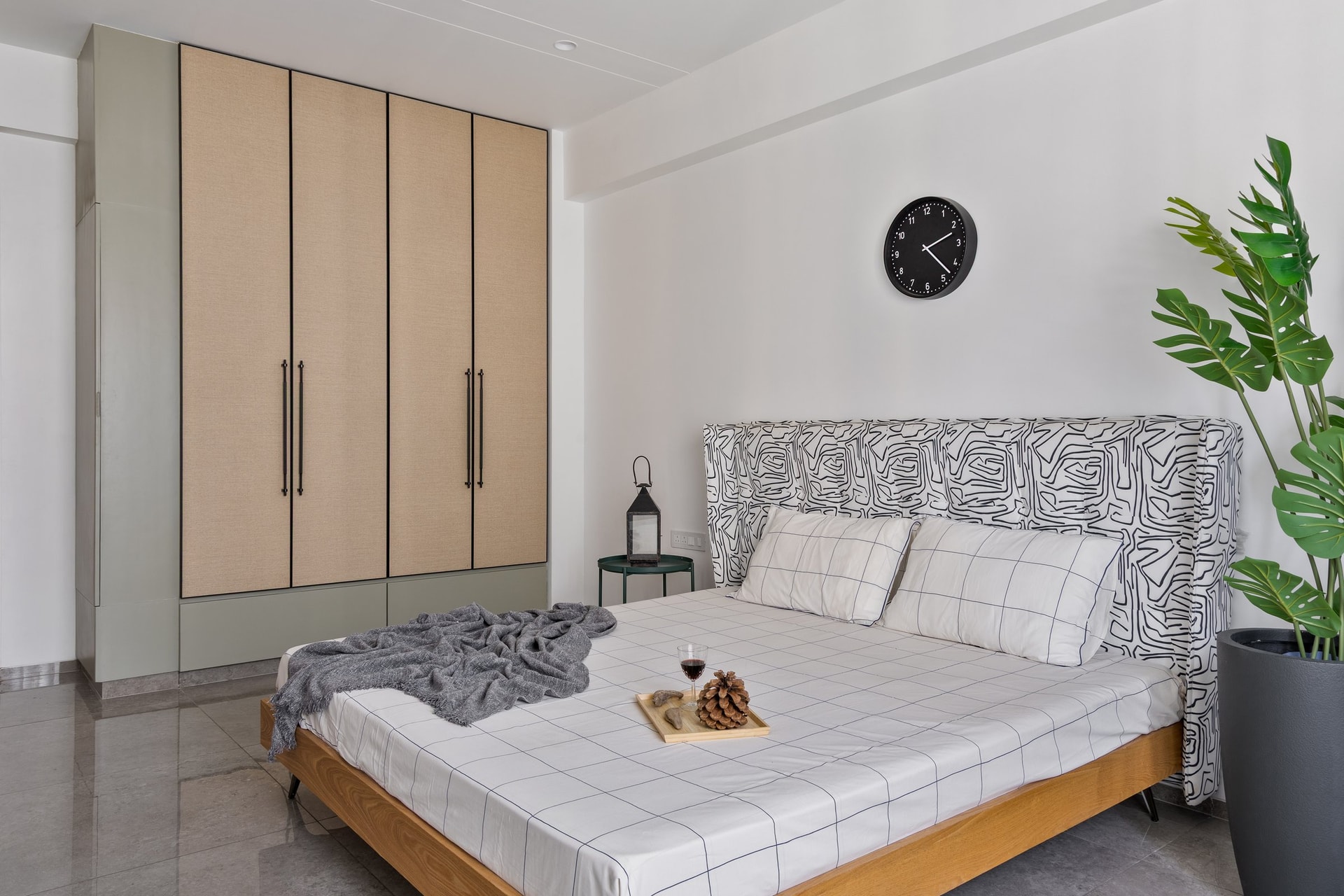 The principal bedroom, where a graphic line-work headboard sits against soft sage and beige cabinetry