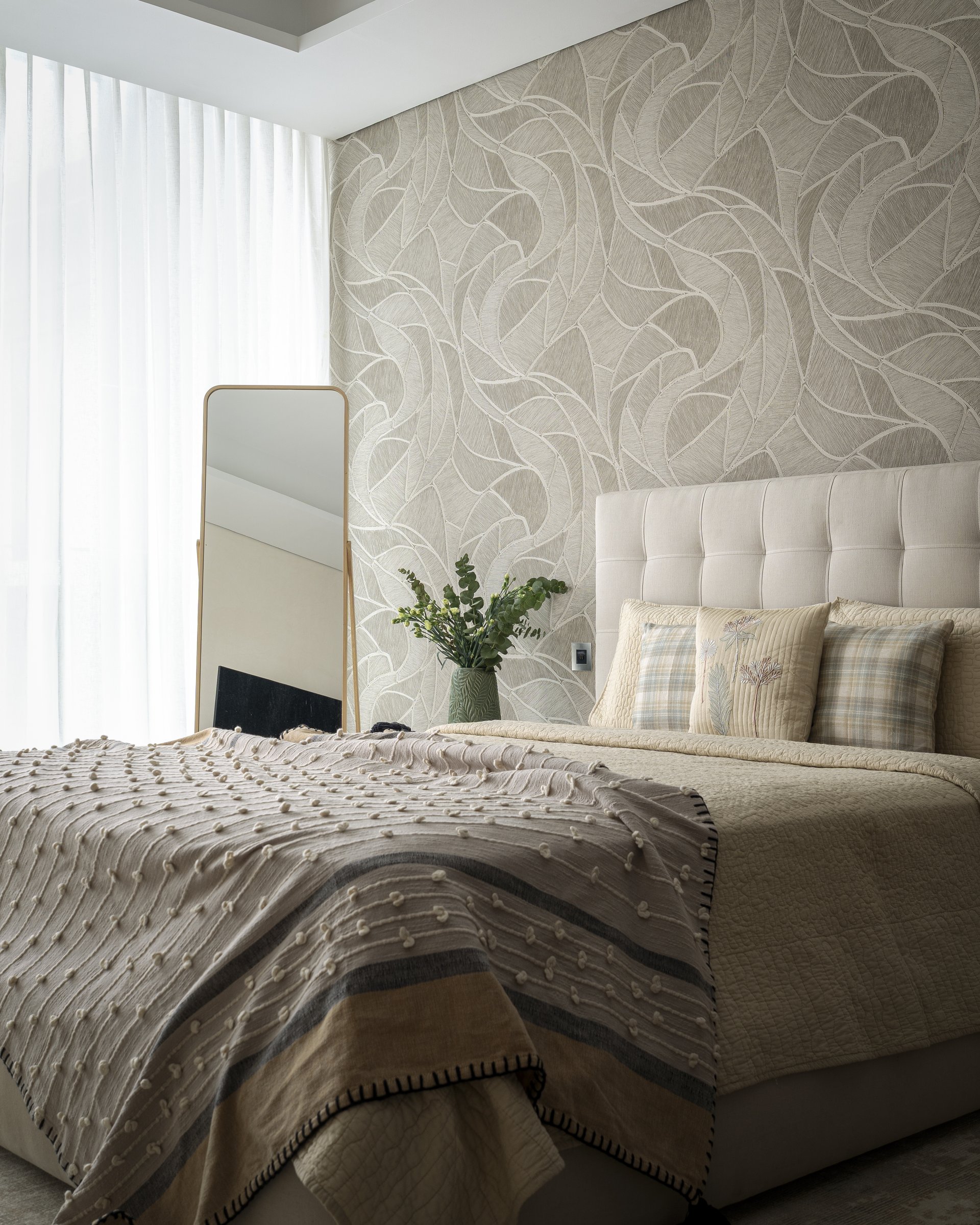The second bedroom, where a textured wallpaper of looping ribbon-like forms holds the room in soft suspension