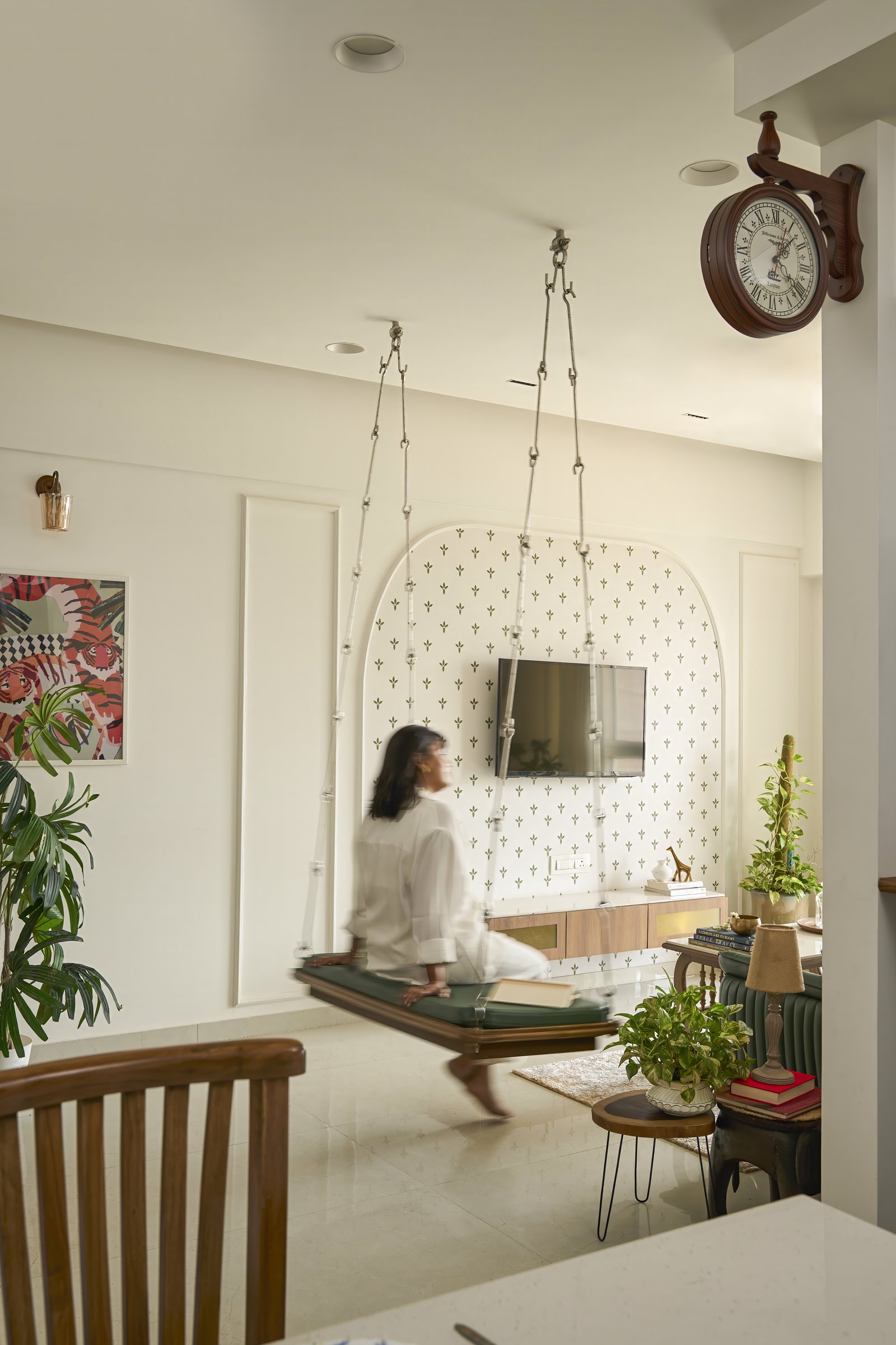 The family swing of over fifty years, suspended in front of an arched stencilled panel and a floating media console