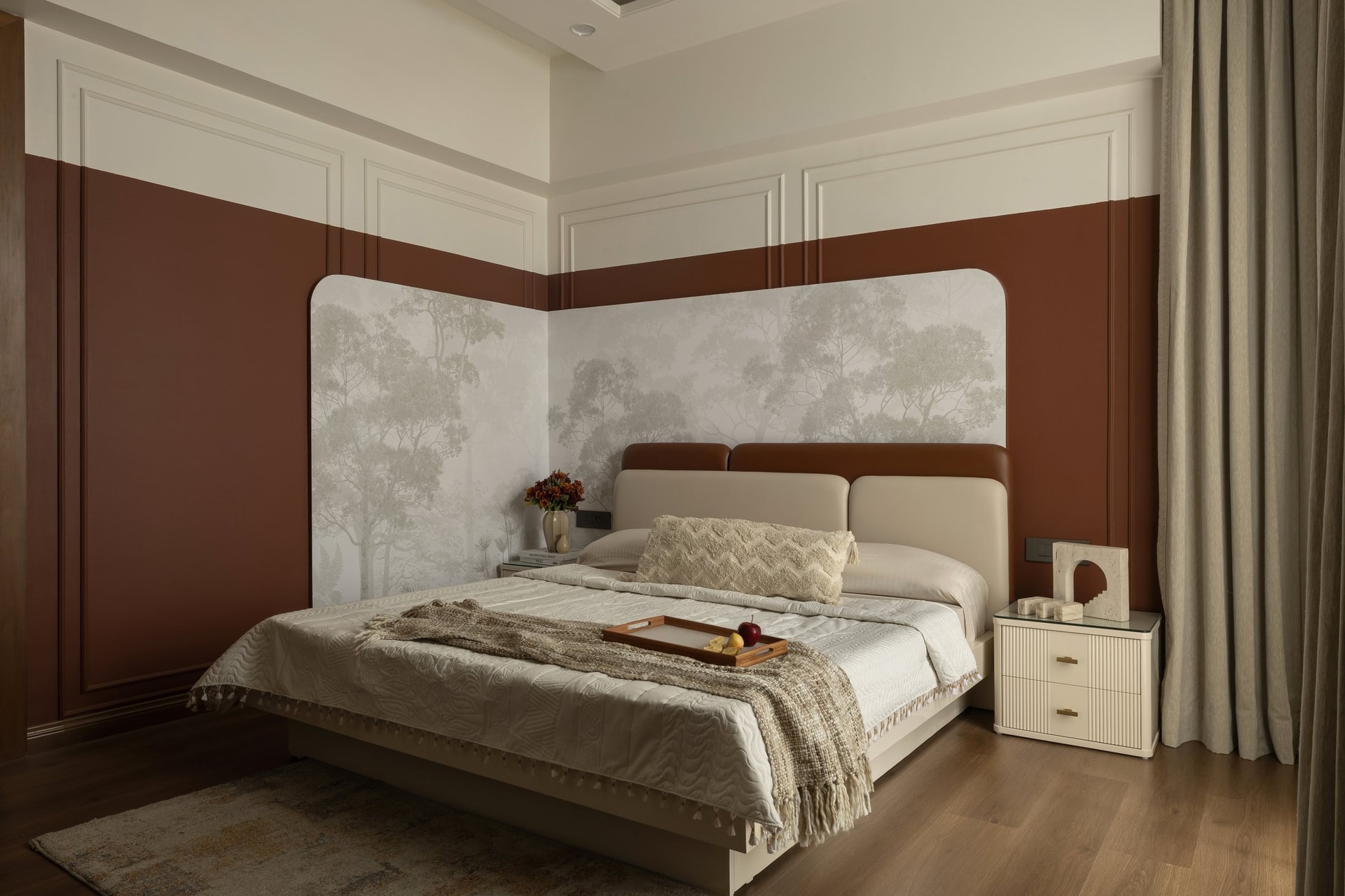 The master bedroom, where an oxblood-and-cream two-tone wall meets a curved leather-and-terracotta headboard