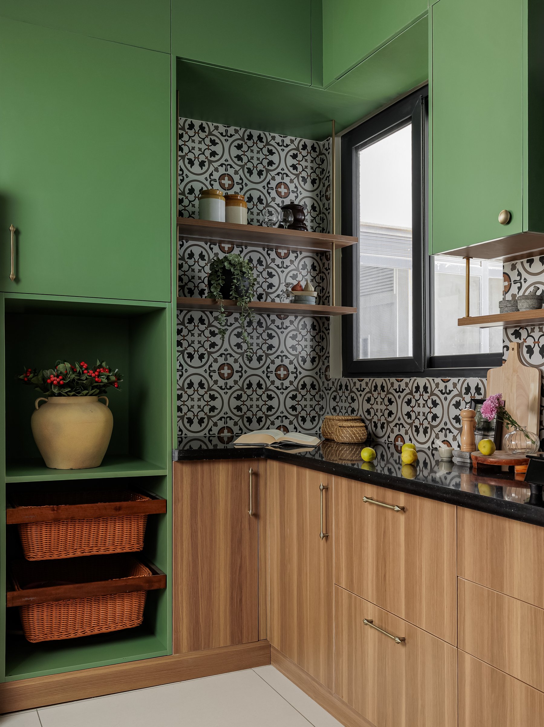 The pantry corner, where open wooden shelves and green-painted niches hold cane baskets and terracotta