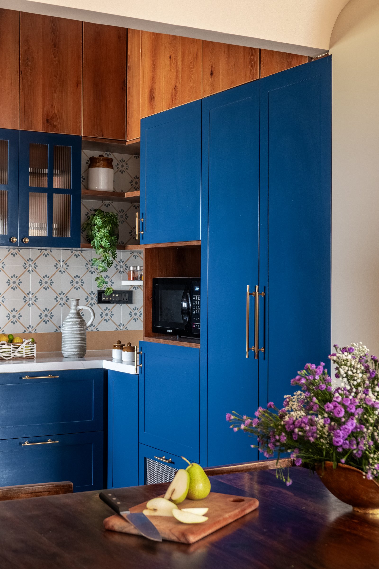 The kitchen's tall storage volume, where reeded-glass cabinets and integrated appliance niches maintain a disciplined material palette