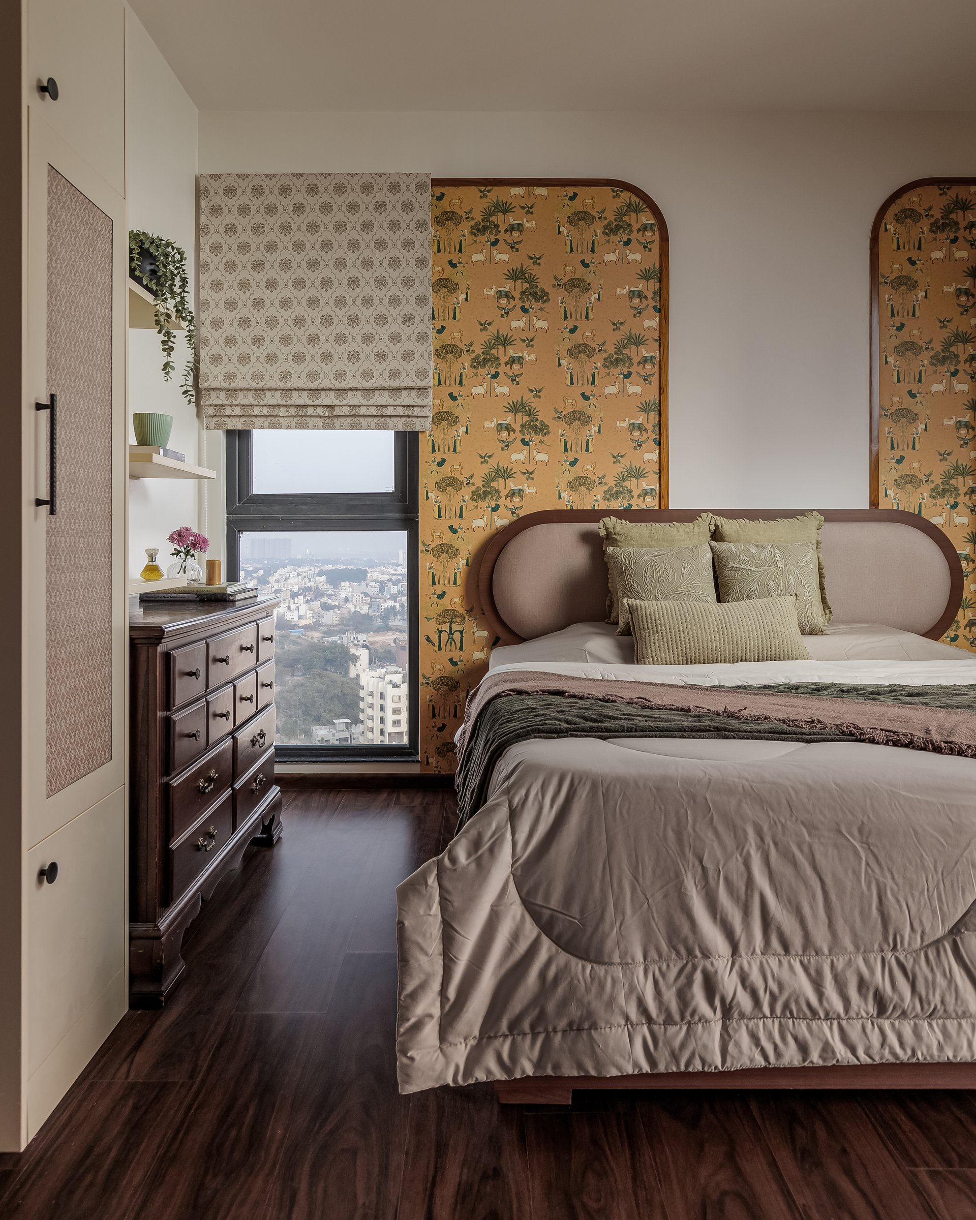 The master bedroom, where twin arched panels in ochre figurative wallpaper frame the bed wall