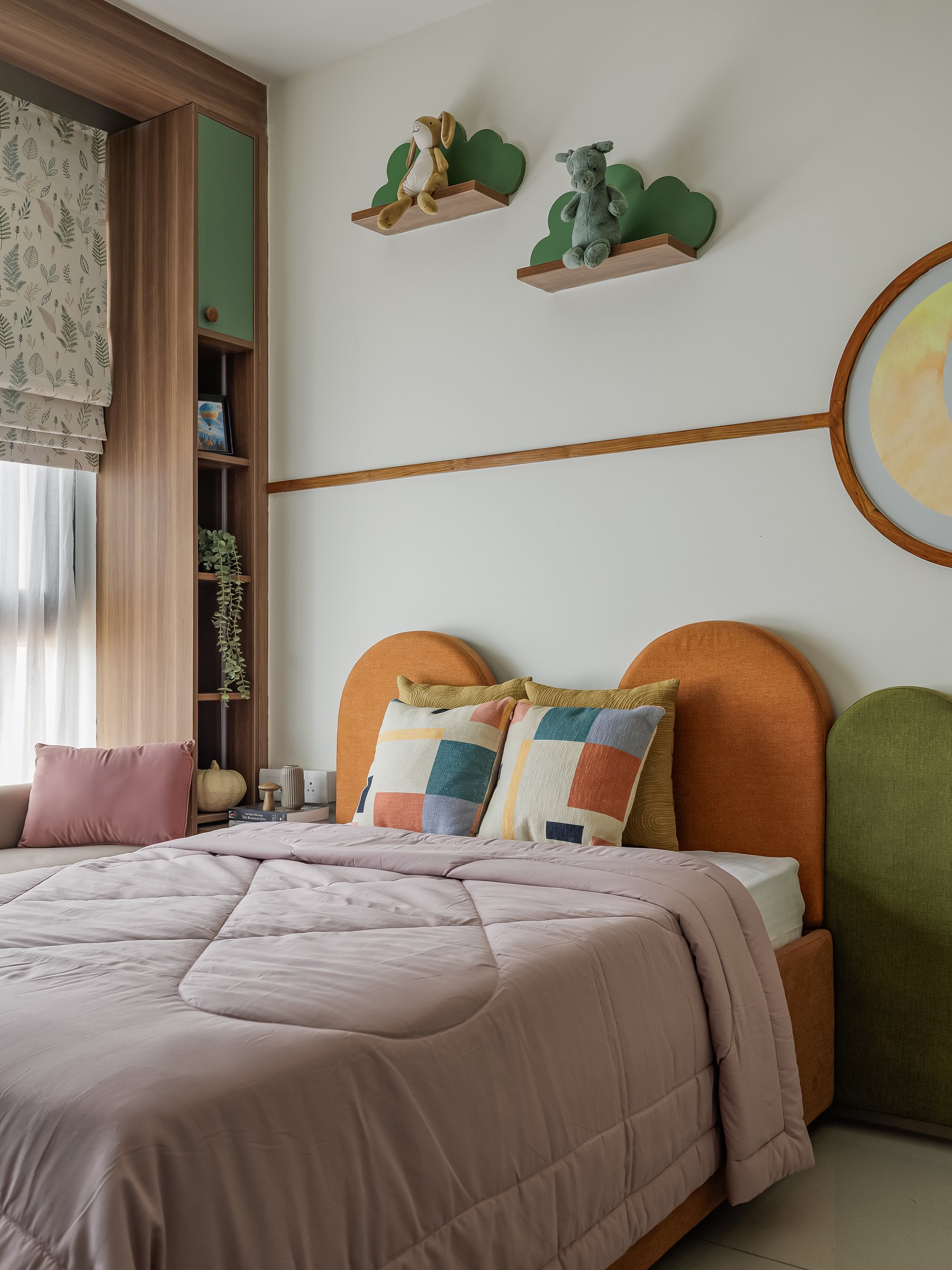 The child's bedroom, where twin arched headboards in rust and olive sit beneath a circular framed illustration