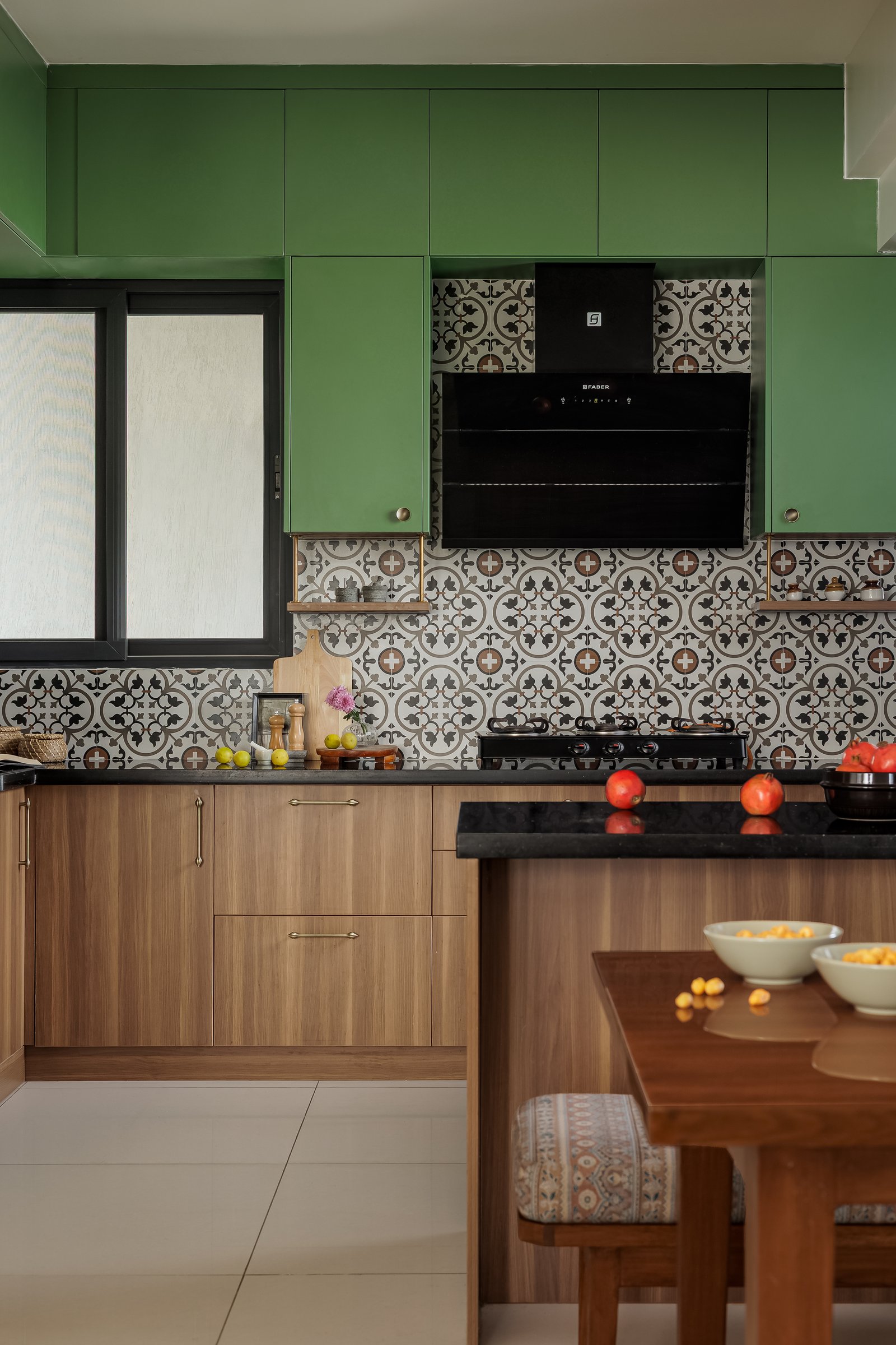 The kitchen, where parrot-green upper cabinetry meets warm timber base units and encaustic-style patterned tile