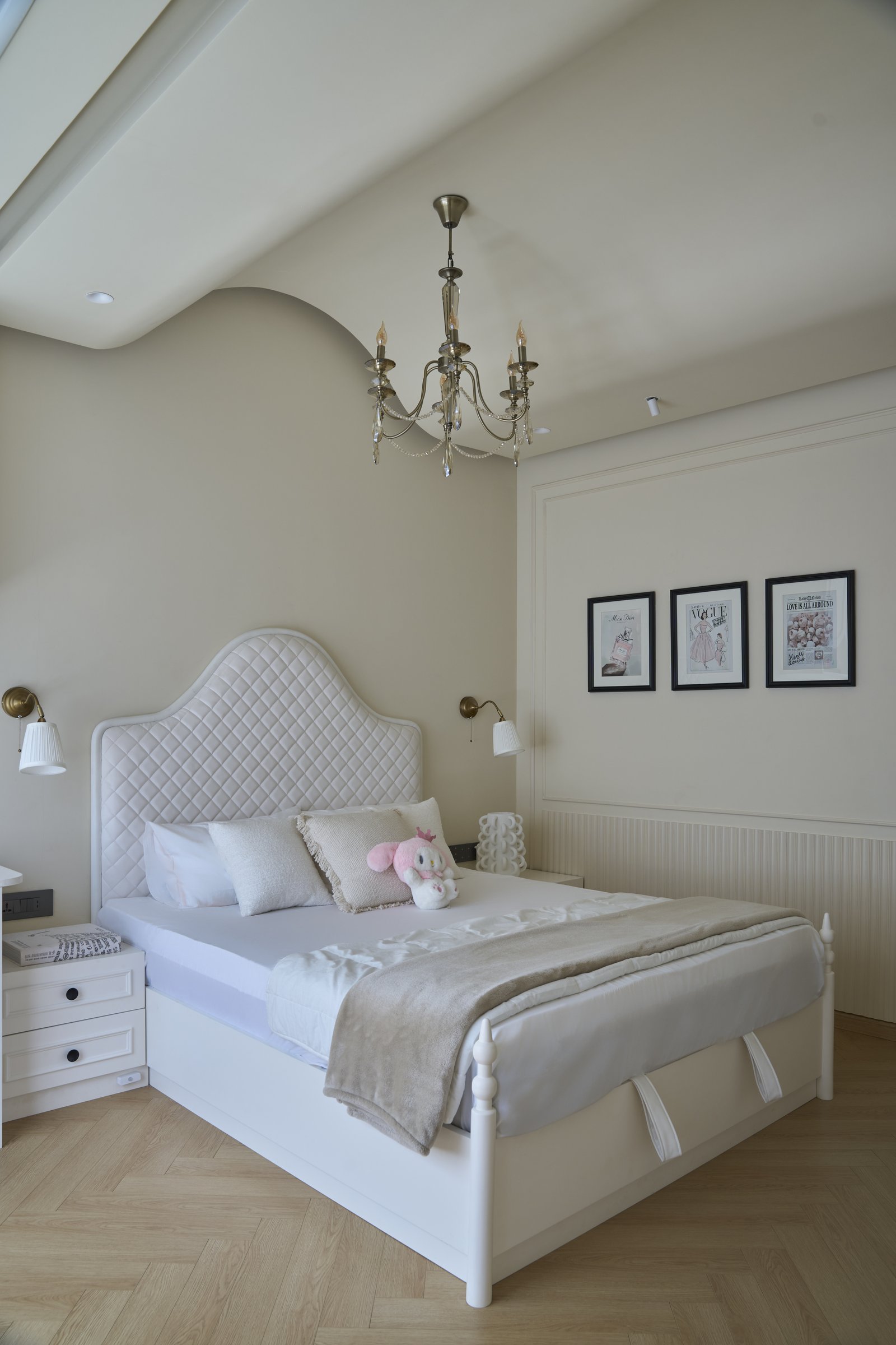 The daughter's bedroom, where a quilted headboard and pleated sconces set a softer tonal direction