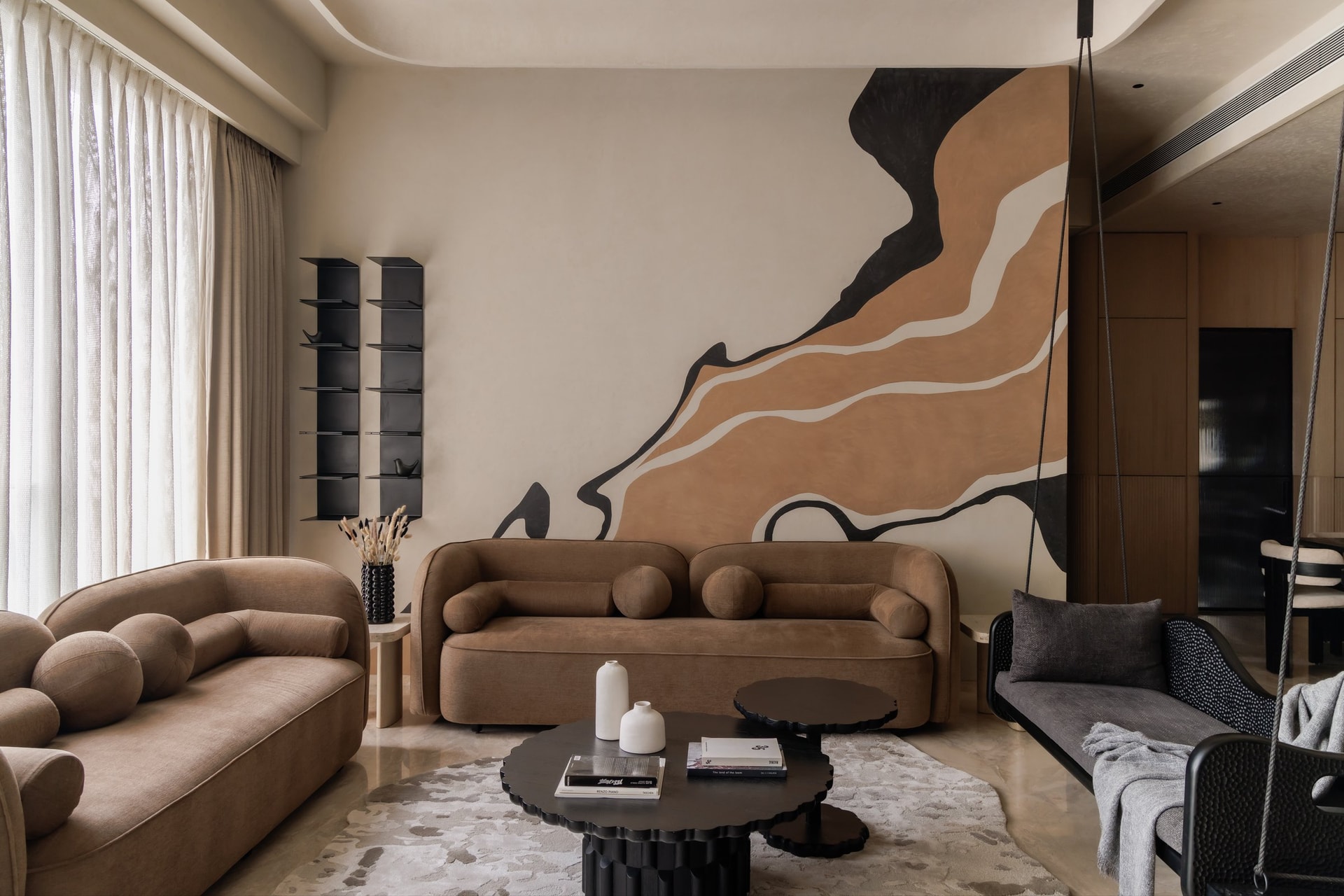 The living room, where a hand-rendered mural in terracotta and charcoal becomes an architectural intervention rather than artwork