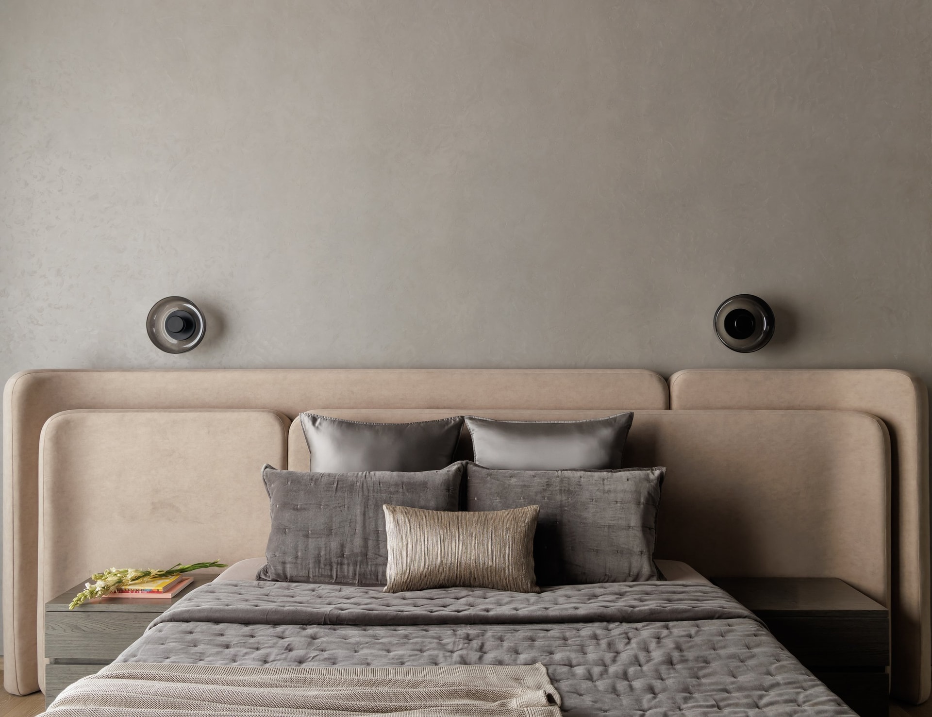 A second bedroom, where a generously scaled headboard in pale taupe suede wraps the bed in two softly curved panels