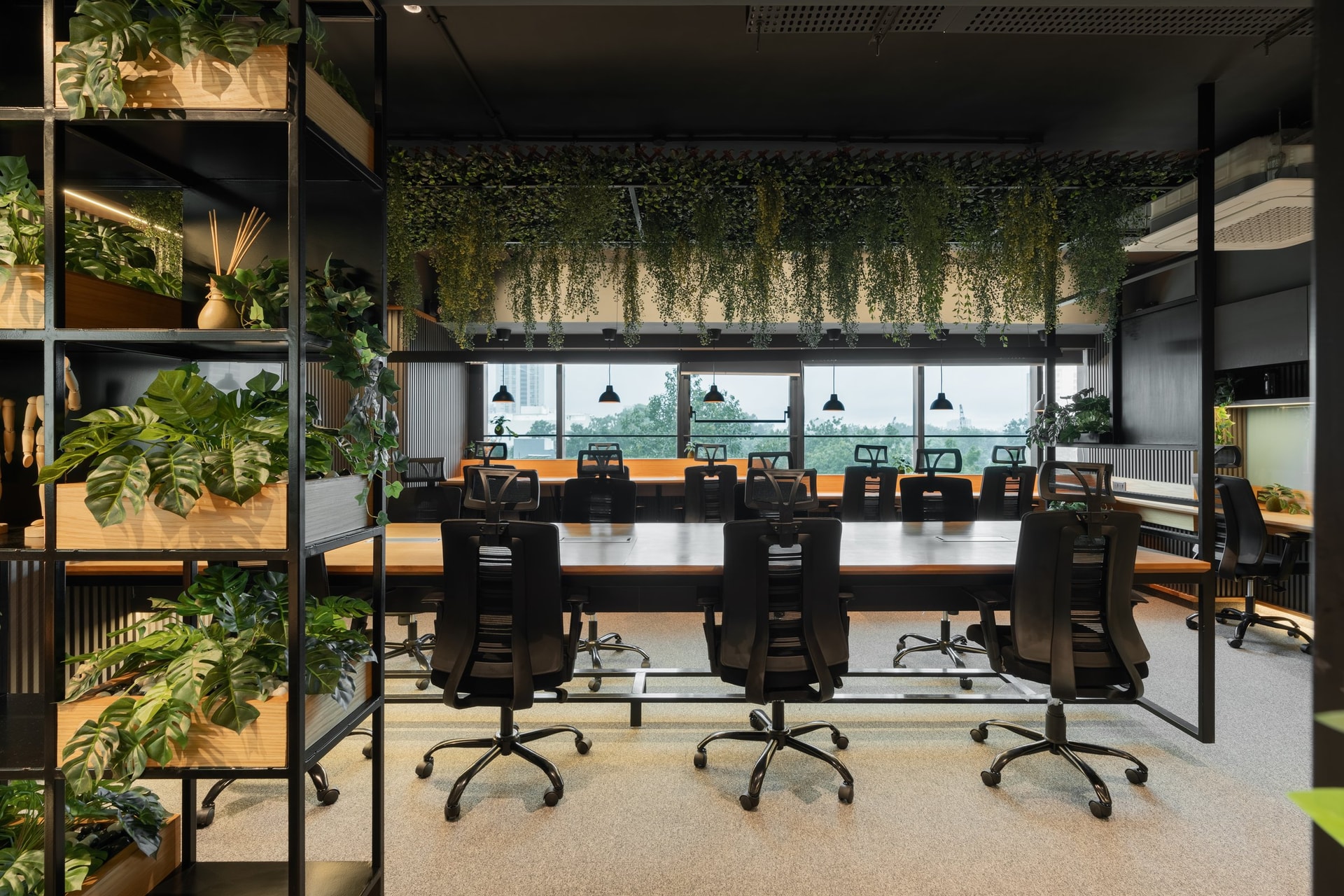 The main workstation area, where a cascade of foliage overhead lowers the ceiling and gives the room its calm register