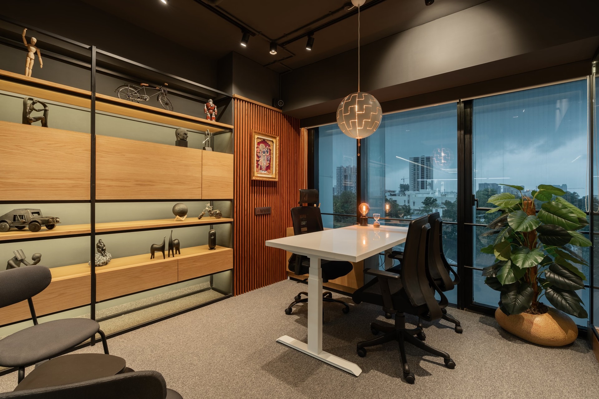 The principal's cabin, where a shelving wall of collected objects meets a fluted rust-toned panel