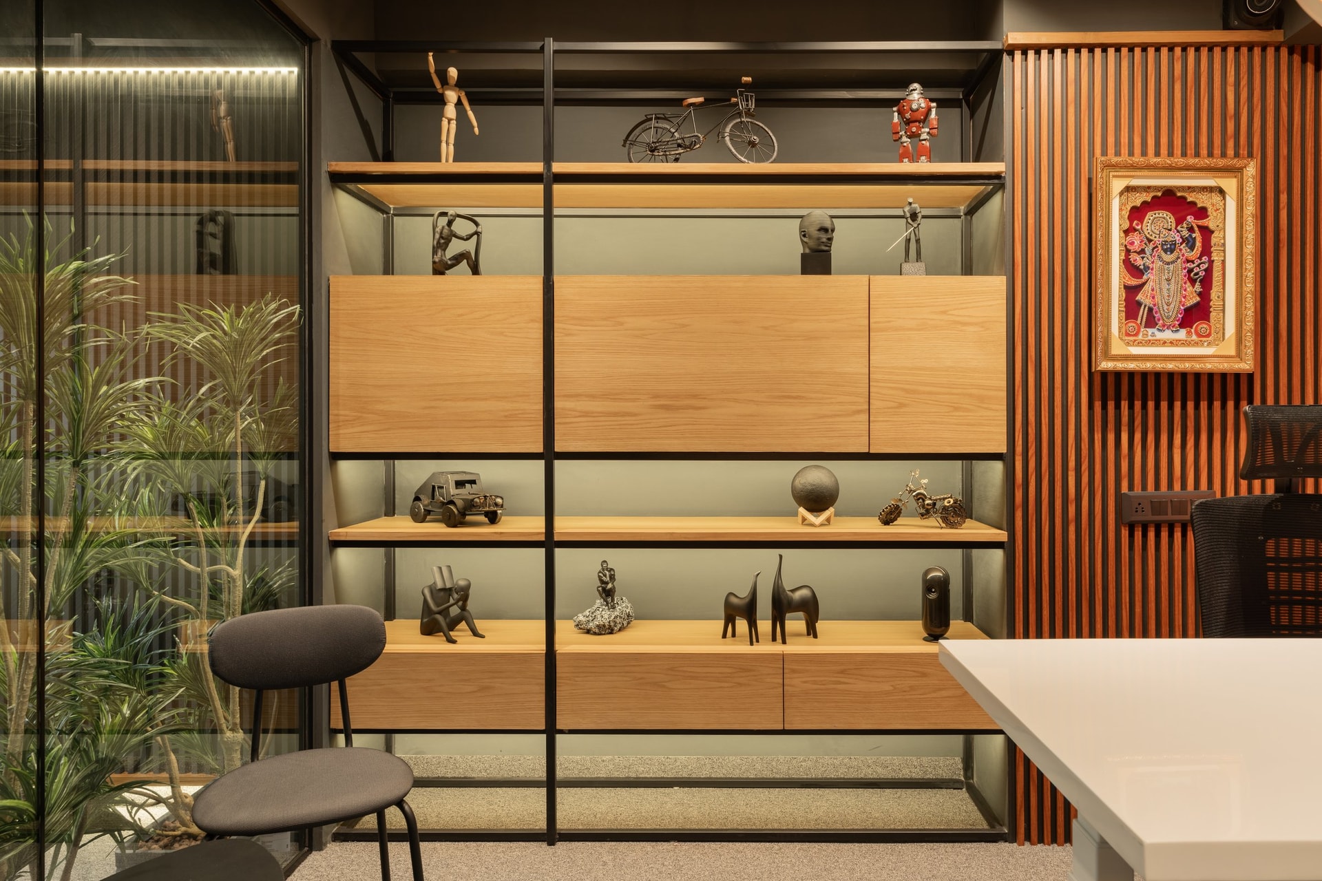 A closer view of the curated display wall, framed by blond wood shelves and a slim black metal grid