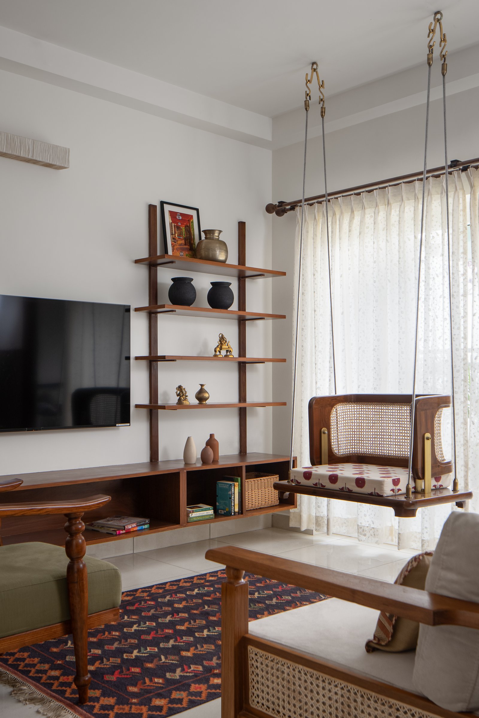 The shelving wall, where brass vessels and small figurines are arranged with the ease of a collected home