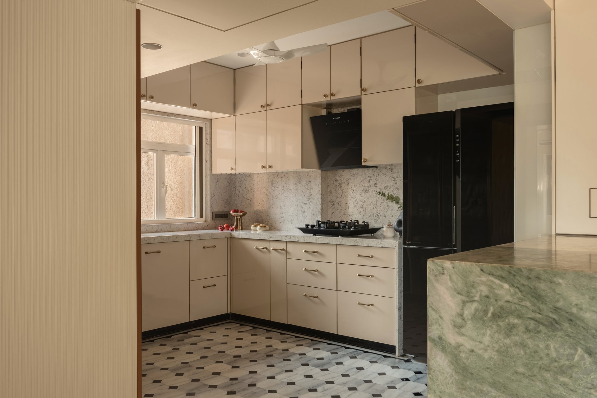 The kitchen is planned for use, with the chequered marble floor echoing the entry