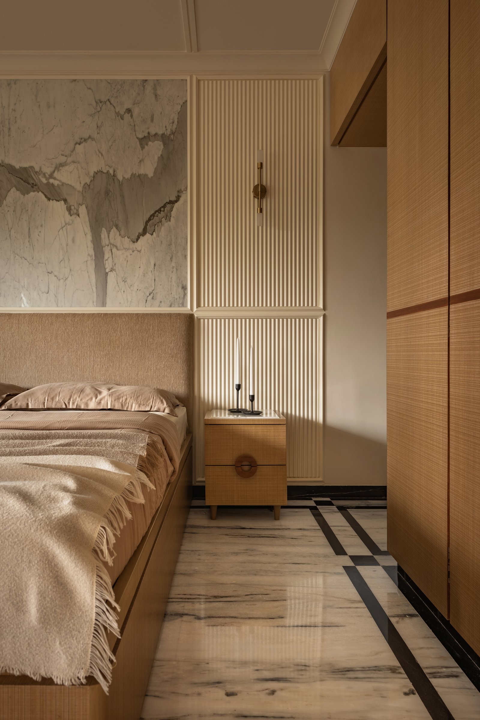 The parents' bedroom pairs a grasscloth-textured headboard with a marble artwork and fluted panelling