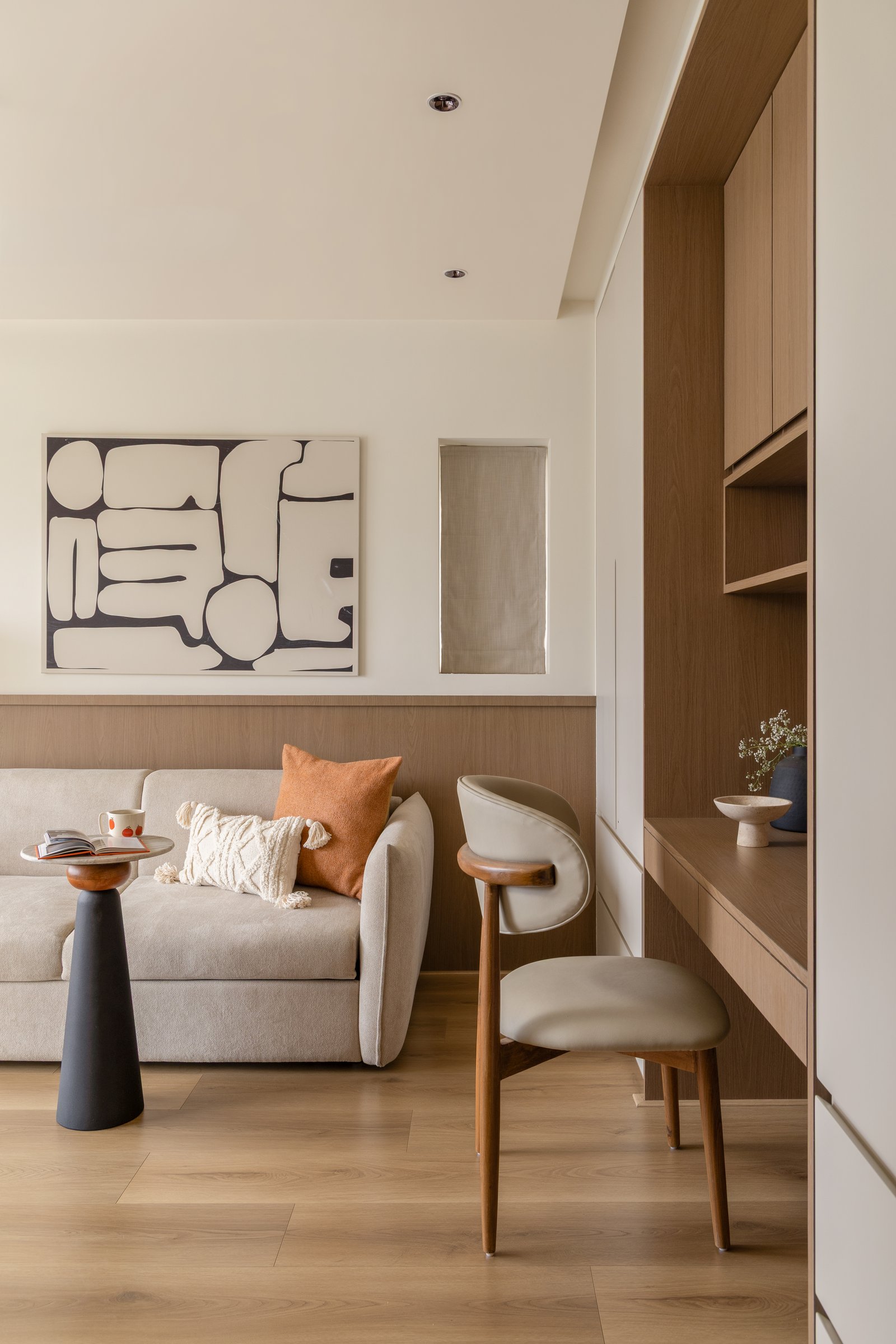 The den, with a compact sofa, timber dado and graphic monochrome artwork
