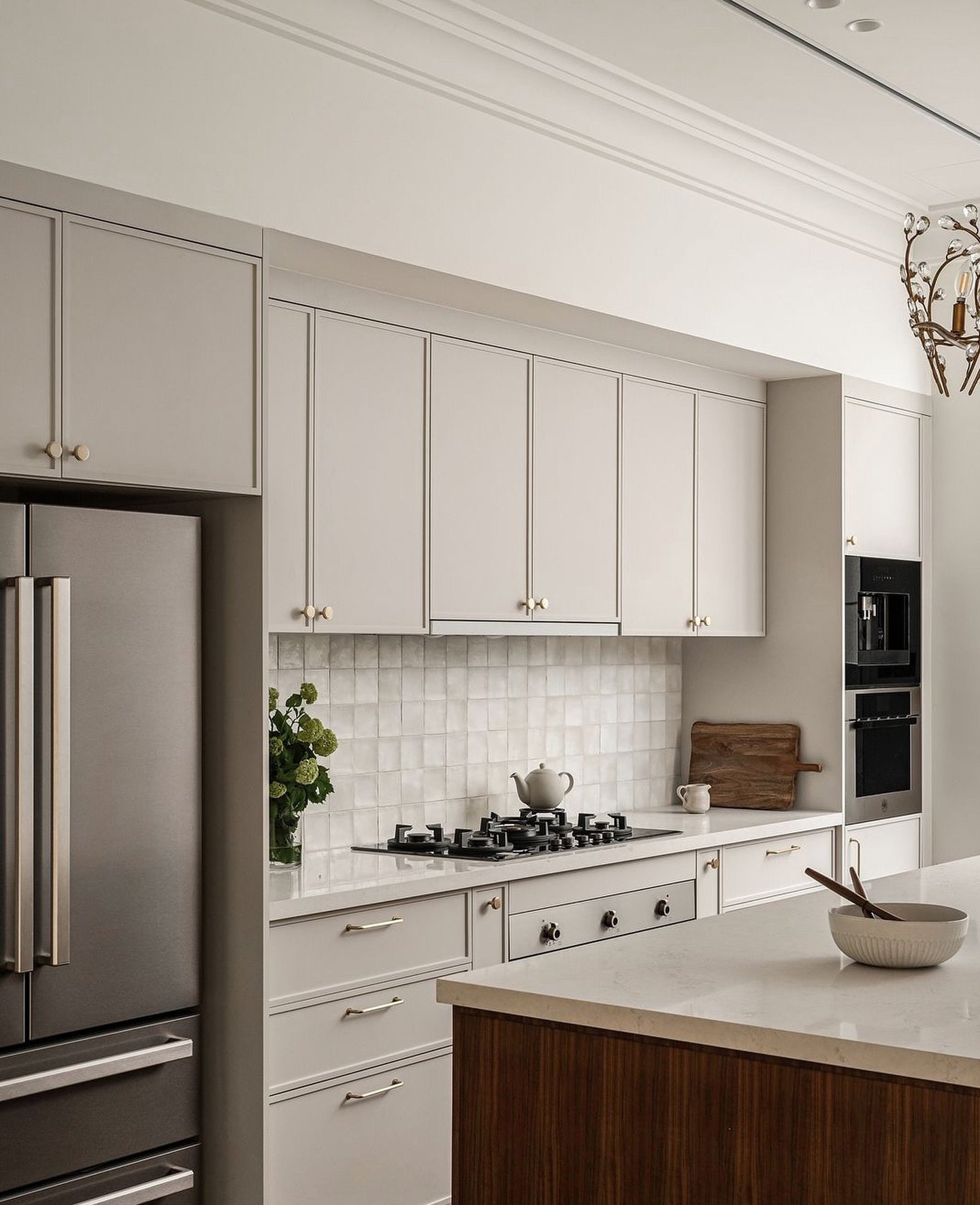 The kitchen, with taupe shaker cabinetry and a handmade tile backsplash.