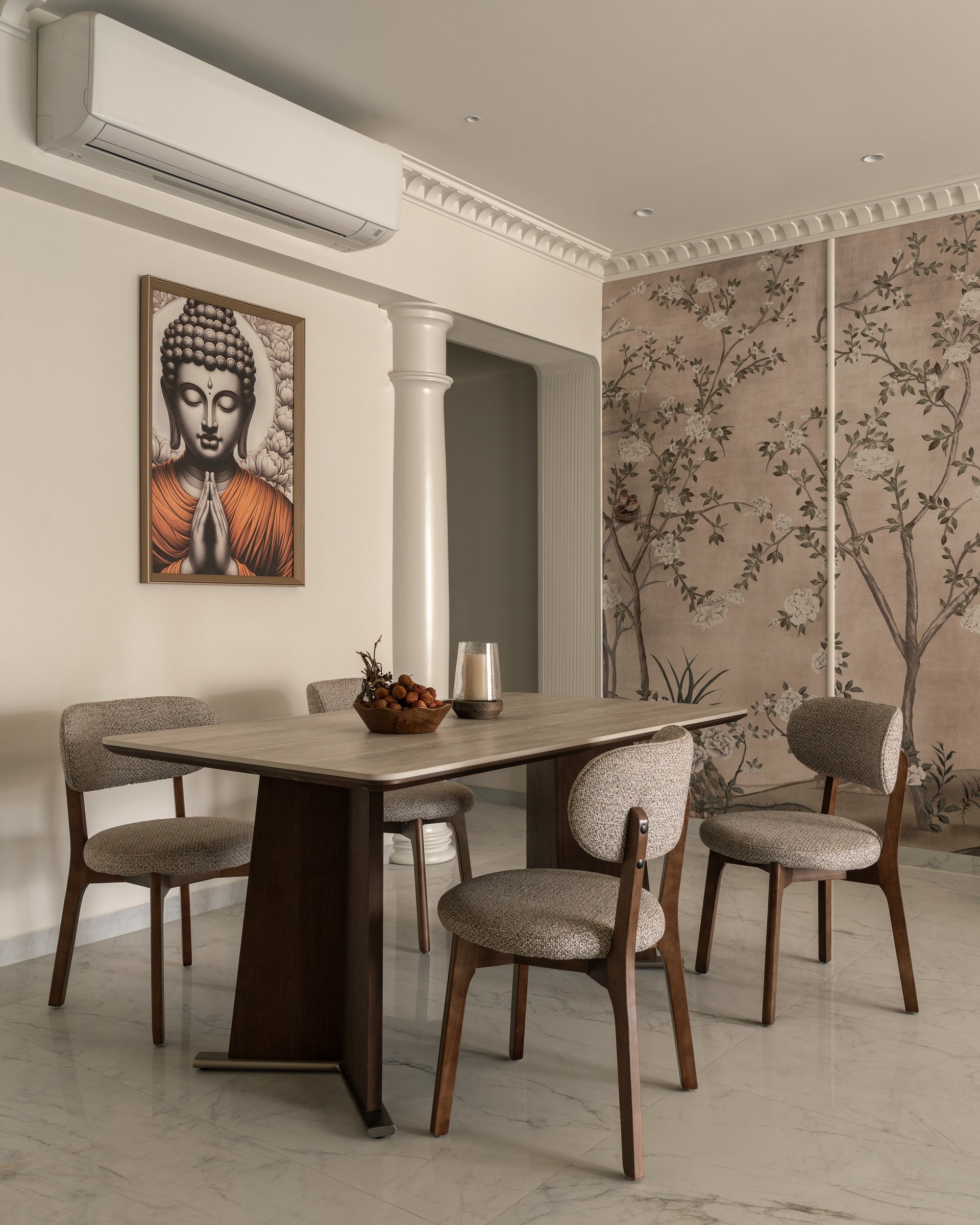 The dining area, anchored by a dark trestle-base table and bouclé-upholstered chairs, with the freestanding column marking the passage beyond