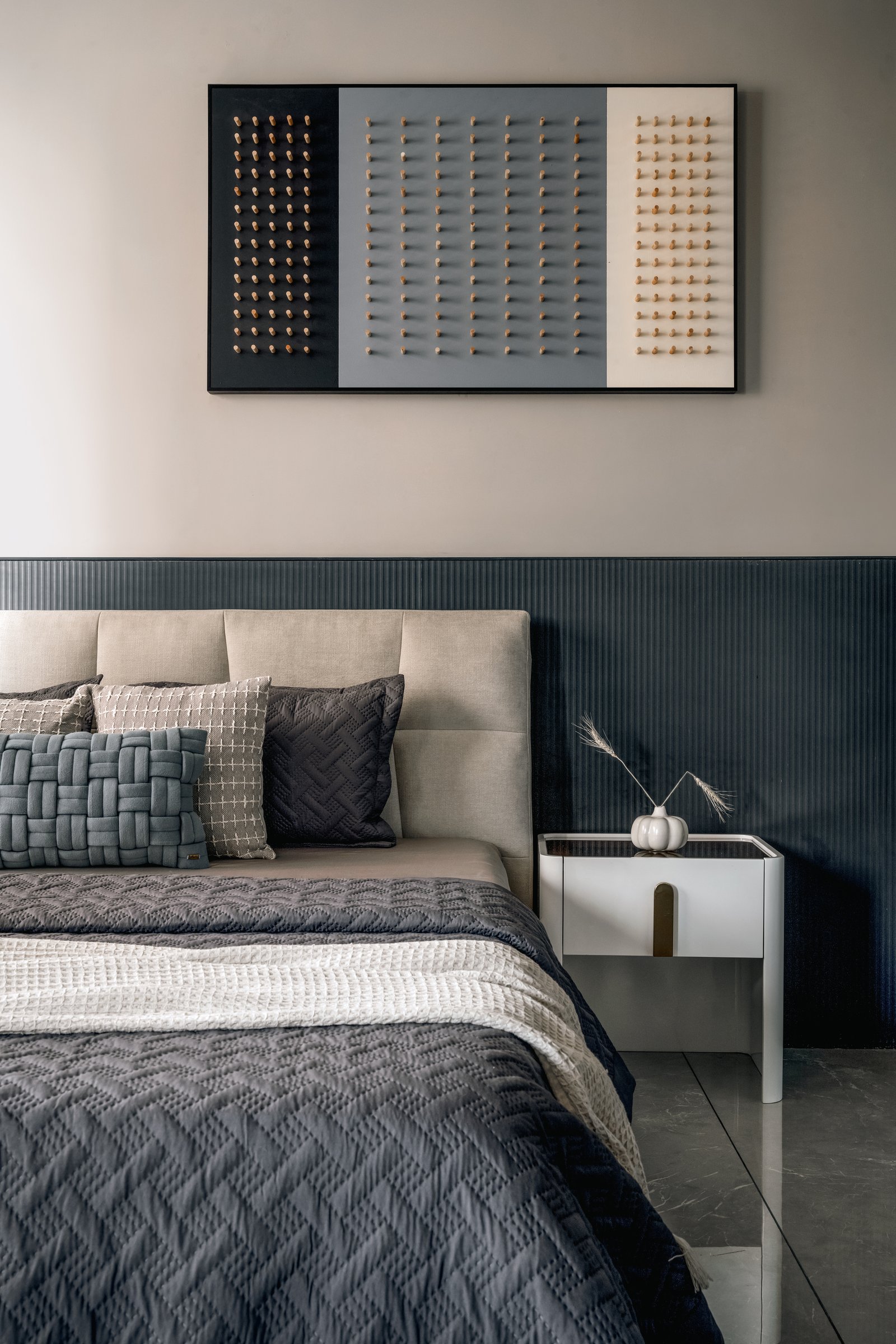 A second bedroom, where a fluted teal panel meets a tactile three-panel artwork above the bed