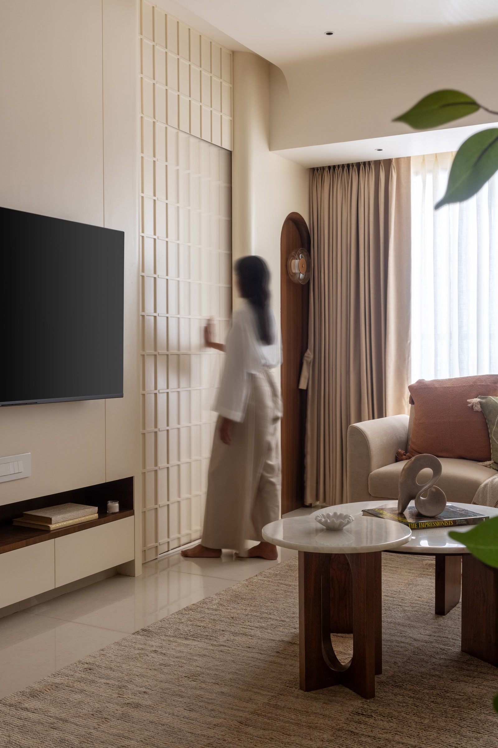 A gridded creamy screen filters light between the living room and the space beyond