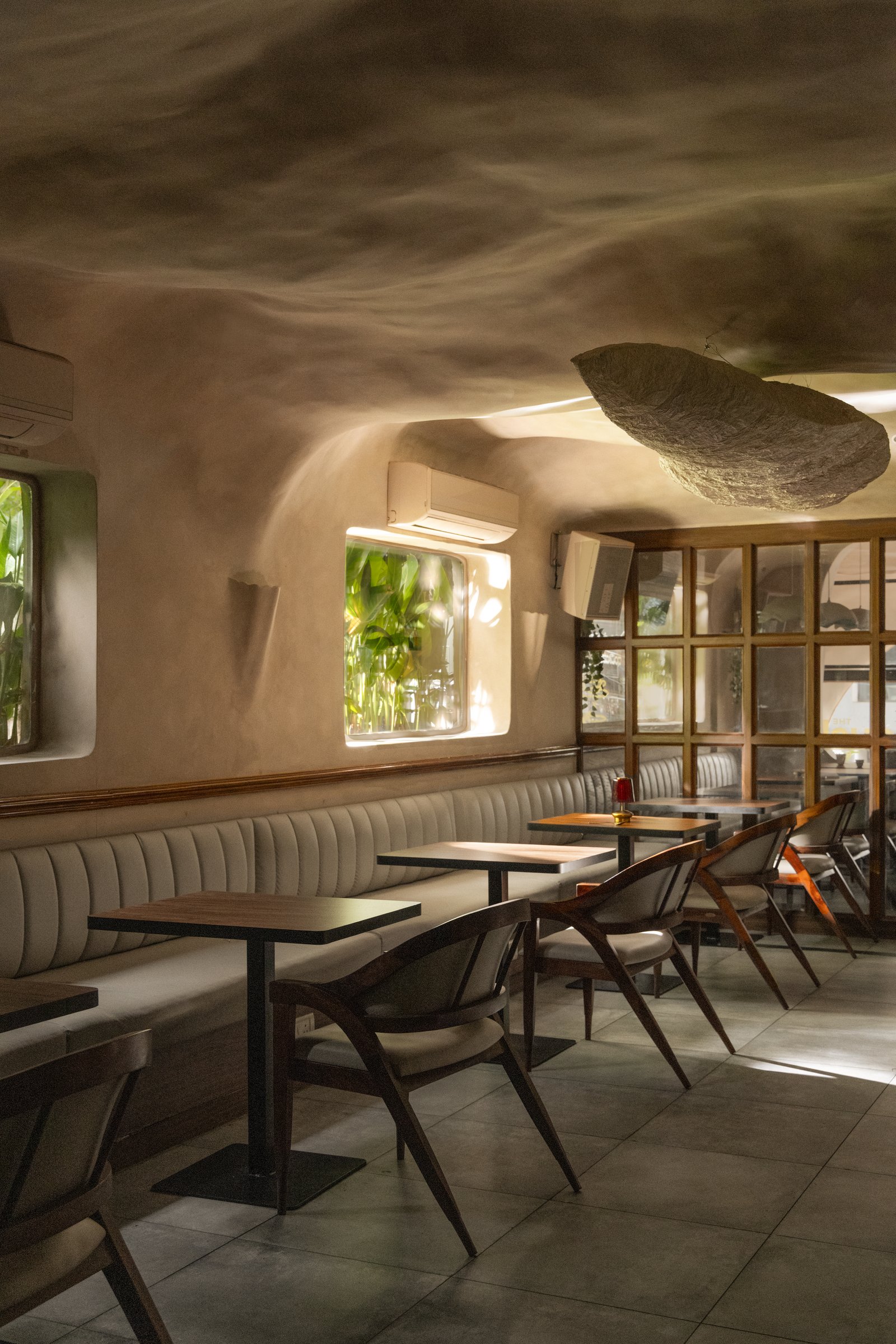A deeper view of the dining room, where a woven pendant marks the transition to the adjoining zone