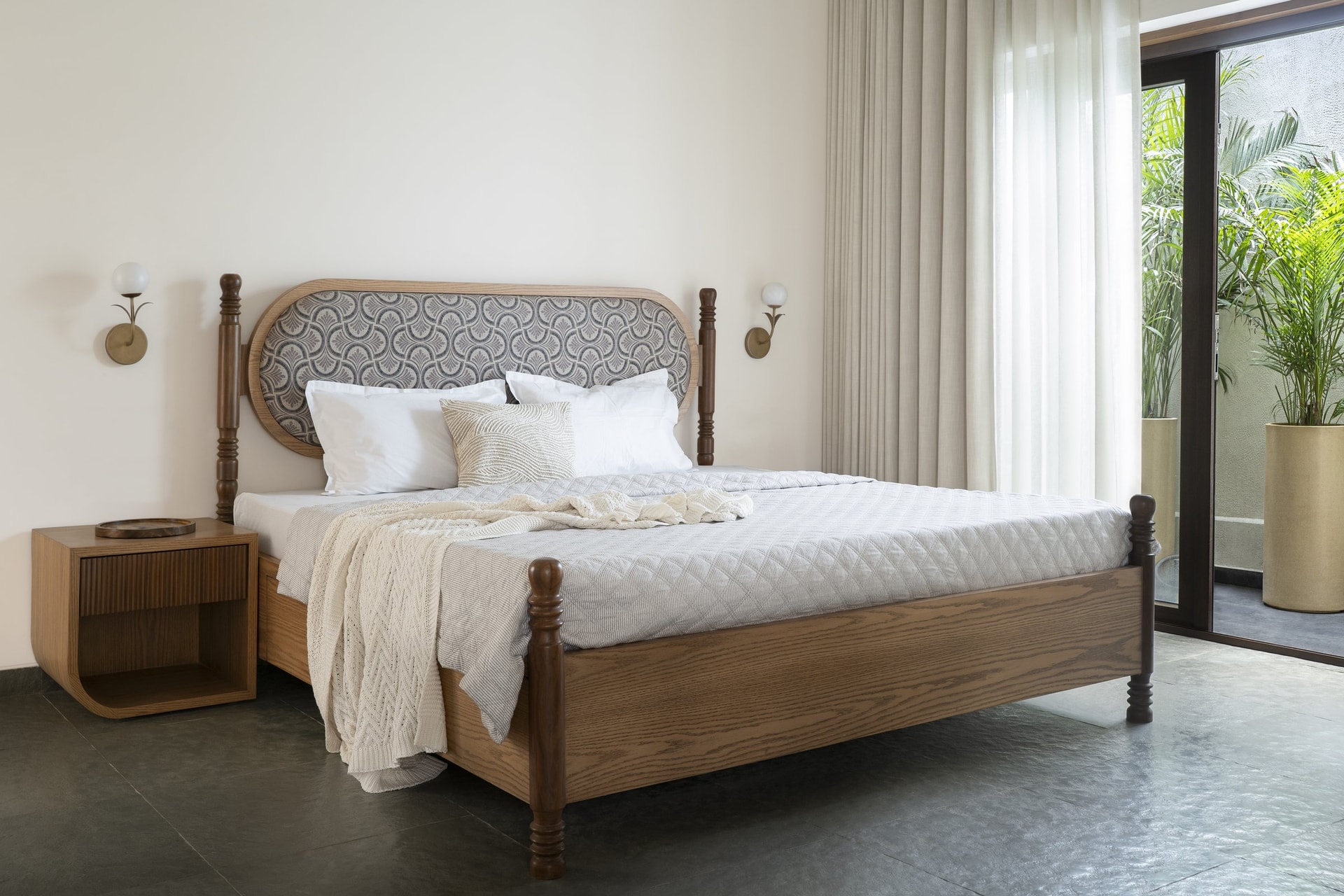 The mother's bedroom, anchored by an arched patterned headboard and turned wooden posts