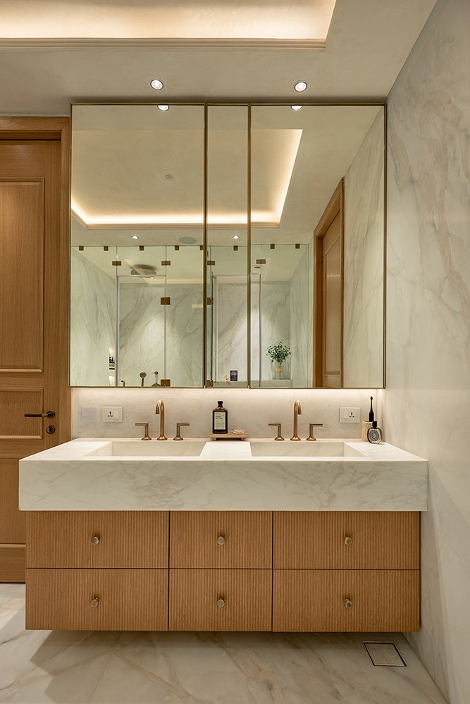 The ensuite vanity, where a veined stone counter sits over cane-fluted oak drawers