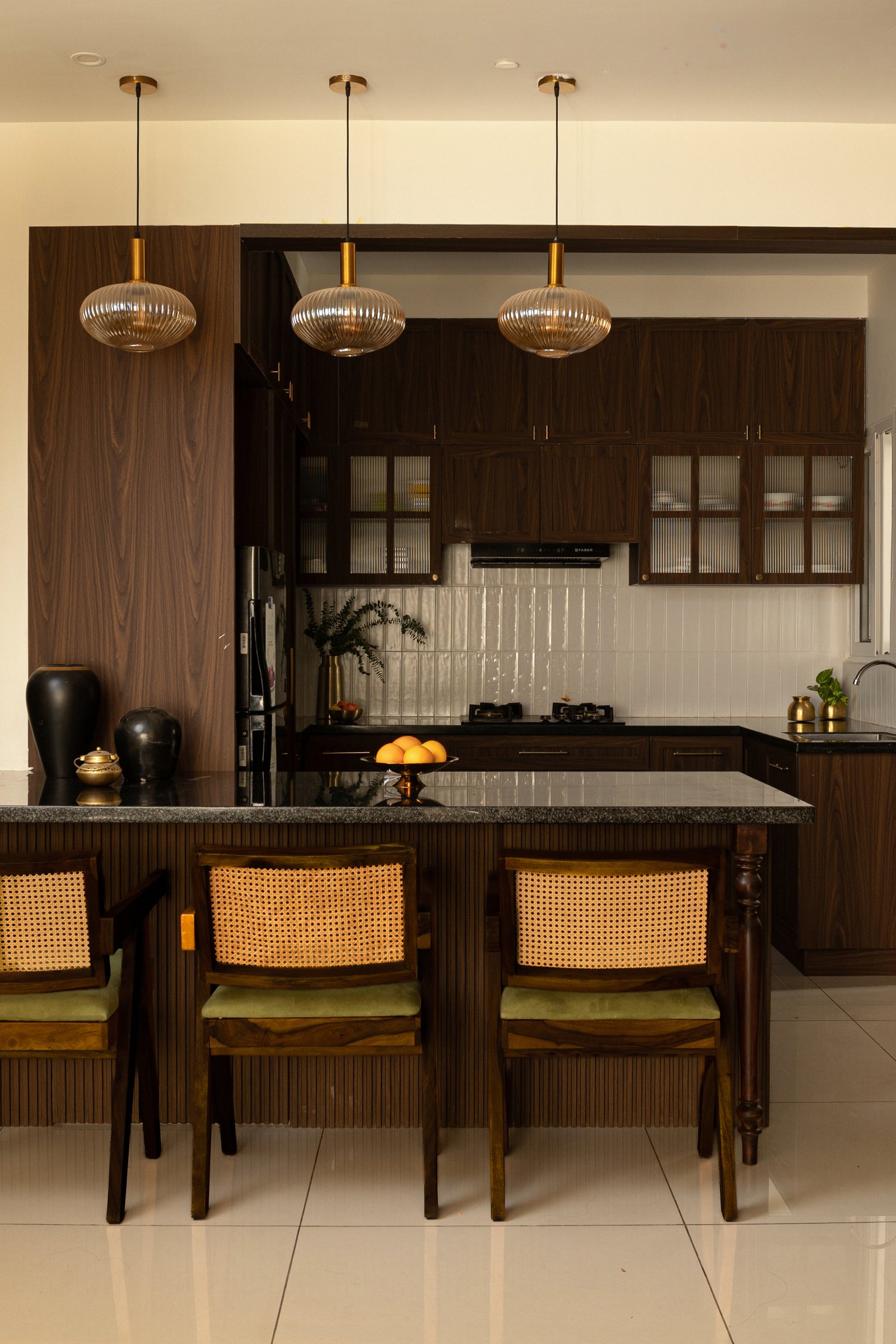 Cane-backed chairs in the Chandigarh language line the counter, lightening the darker joinery behind