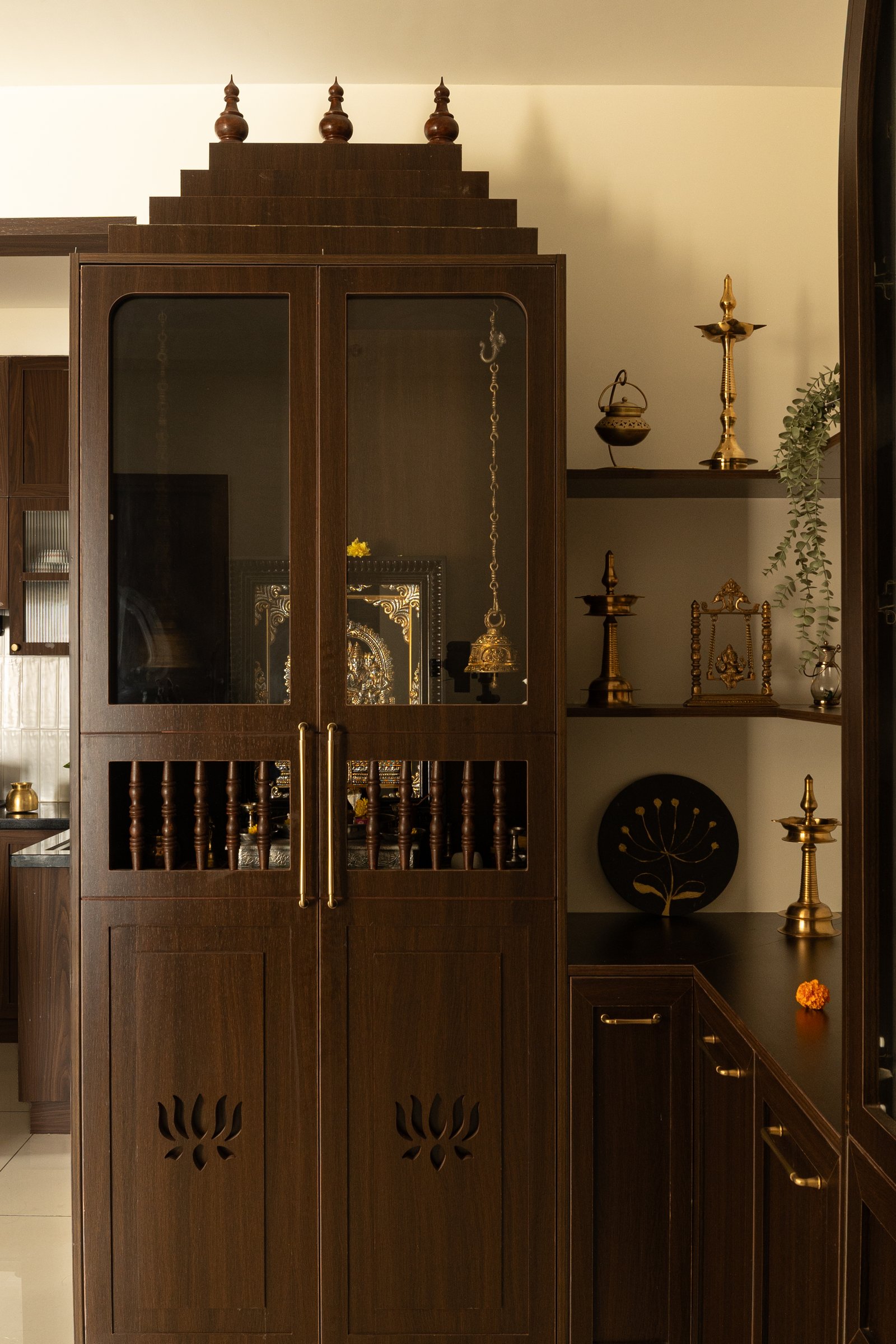 The puja enclosure, a stepped wooden cabinet with lotus cutouts that recalls the spatial logic of traditional South Indian shrines
