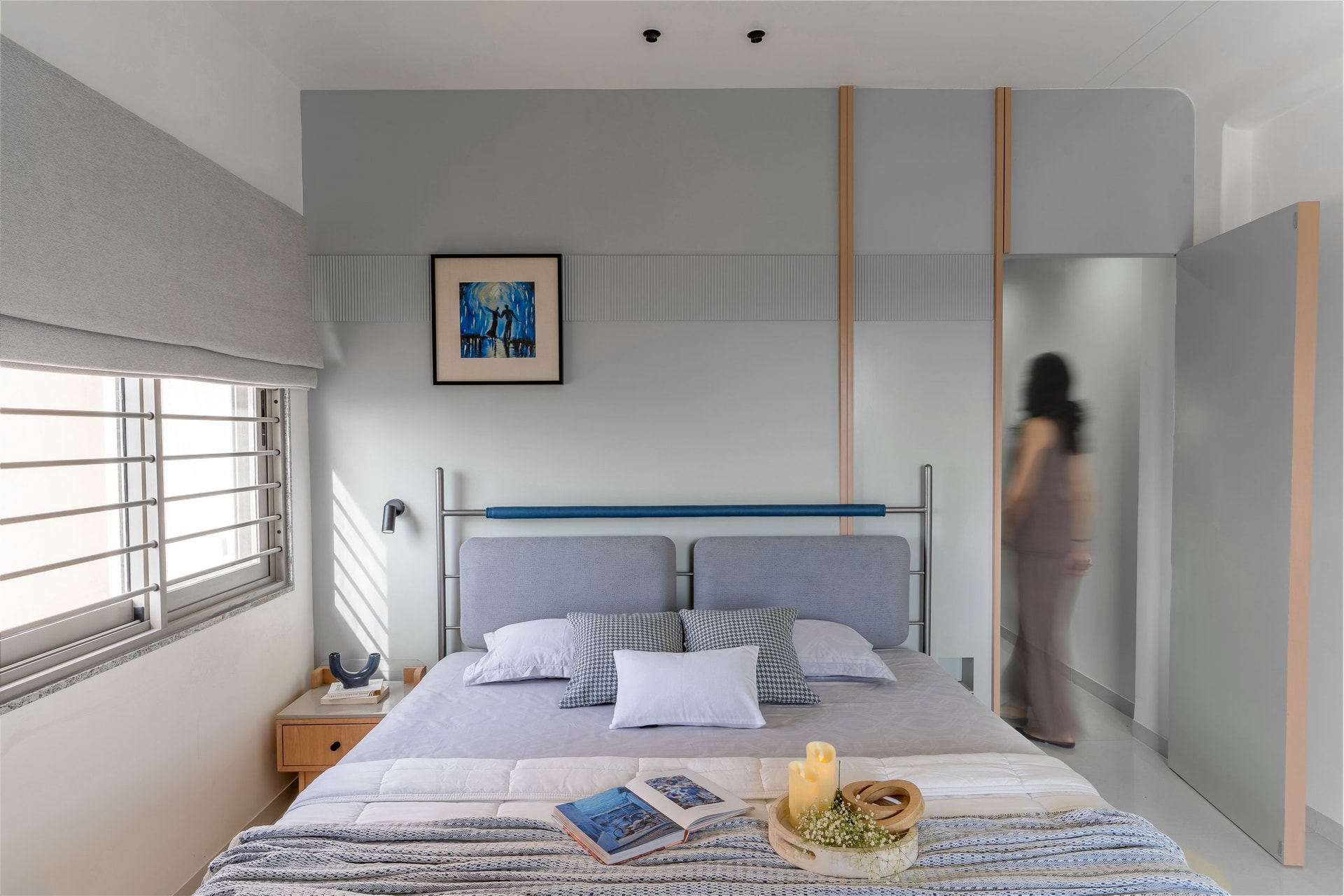 The second bedroom, built around soft greys and a steel-framed headboard with a reeded graphic detail above