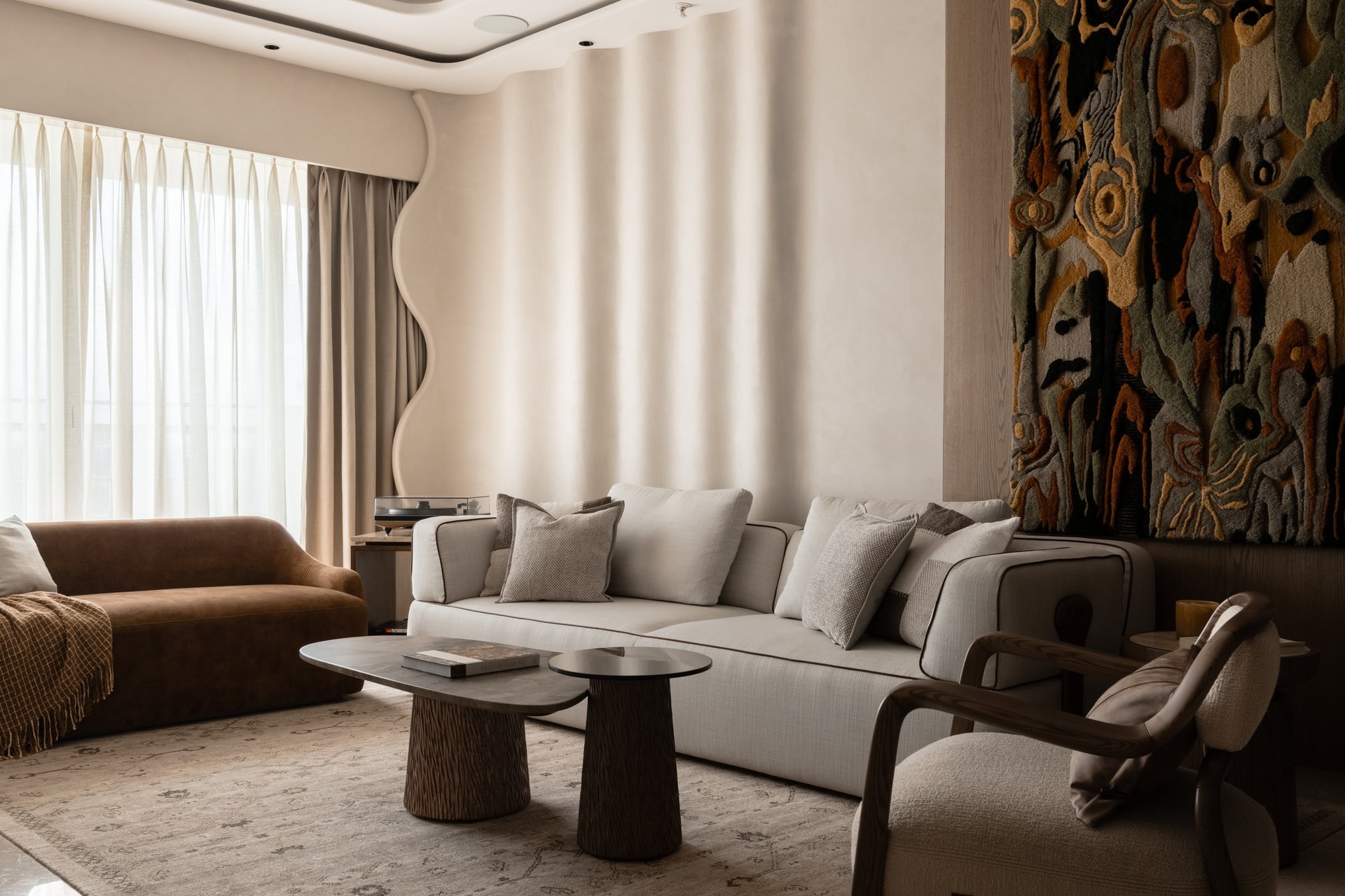 The curved plaster wall behind the sofa, catching light across its vertical ridges