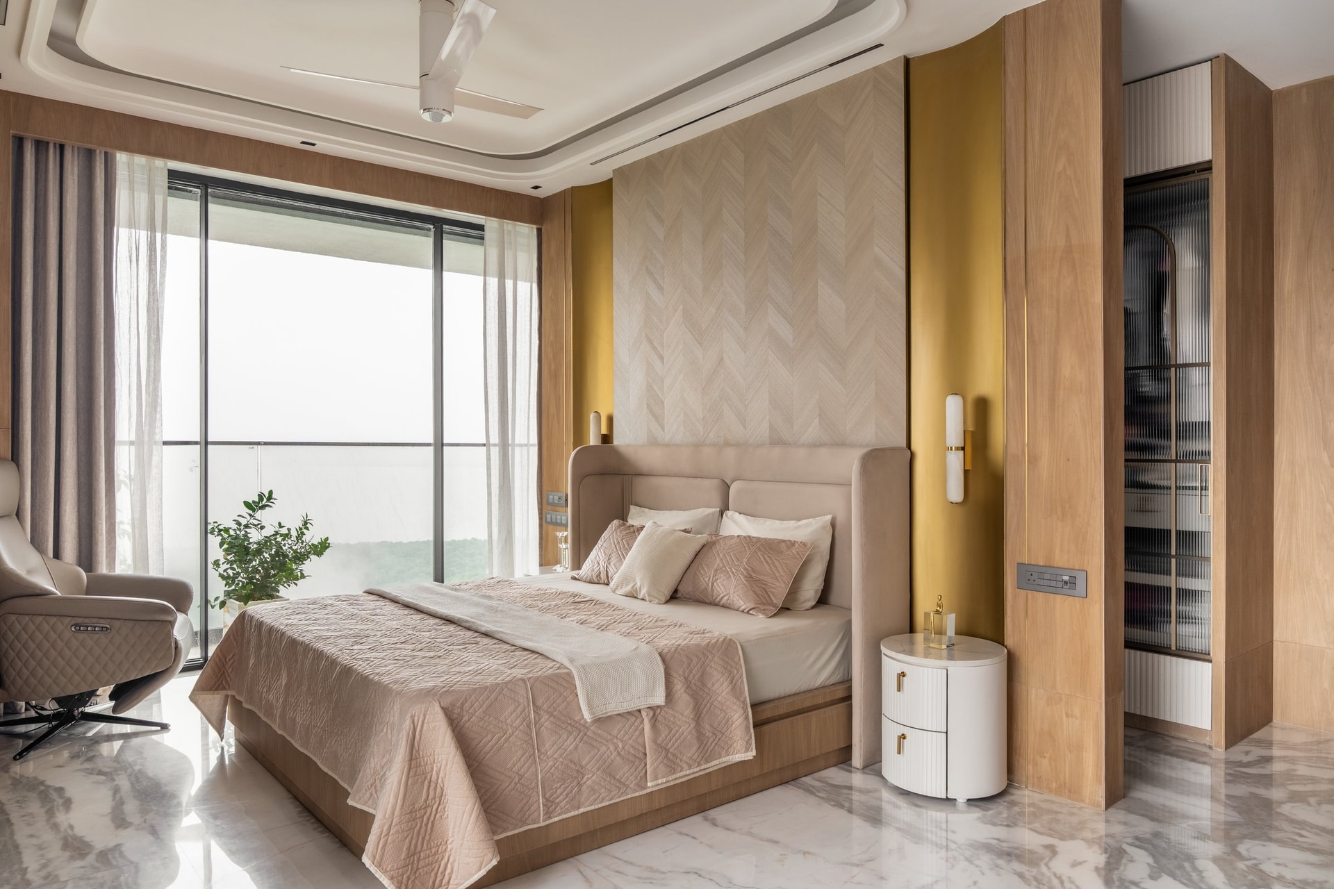 The master bedroom, where a chevron-patterned veneered wall and ochre inlays set the suite's calmer palette