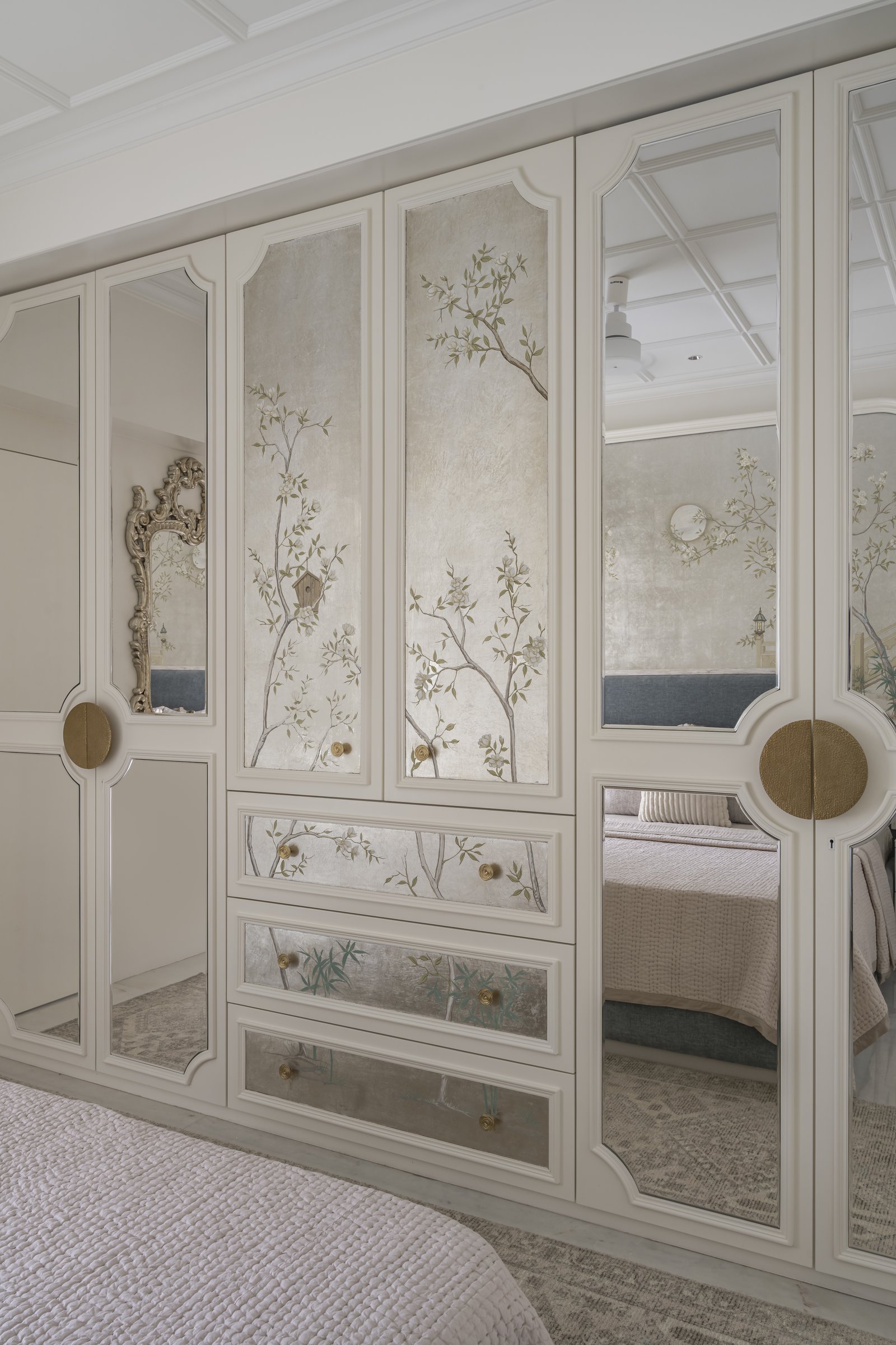 The dressing wall, where Chinoiserie-painted panels alternate with mirrored inserts framed in classical mouldings