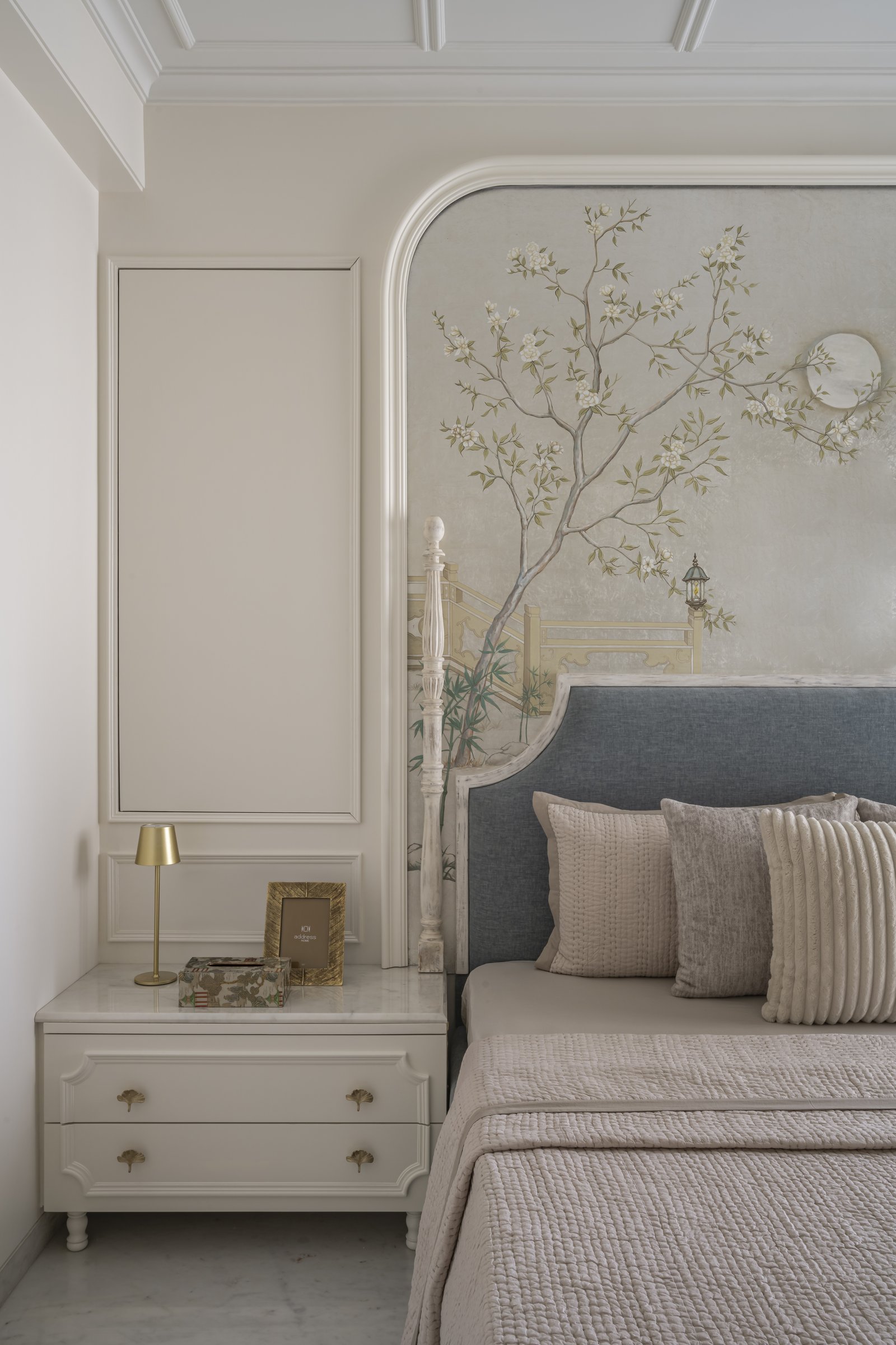 The side composition of the master bedroom, with its moulded panelling and ginkgo-leaf brass pulls on the bedside console
