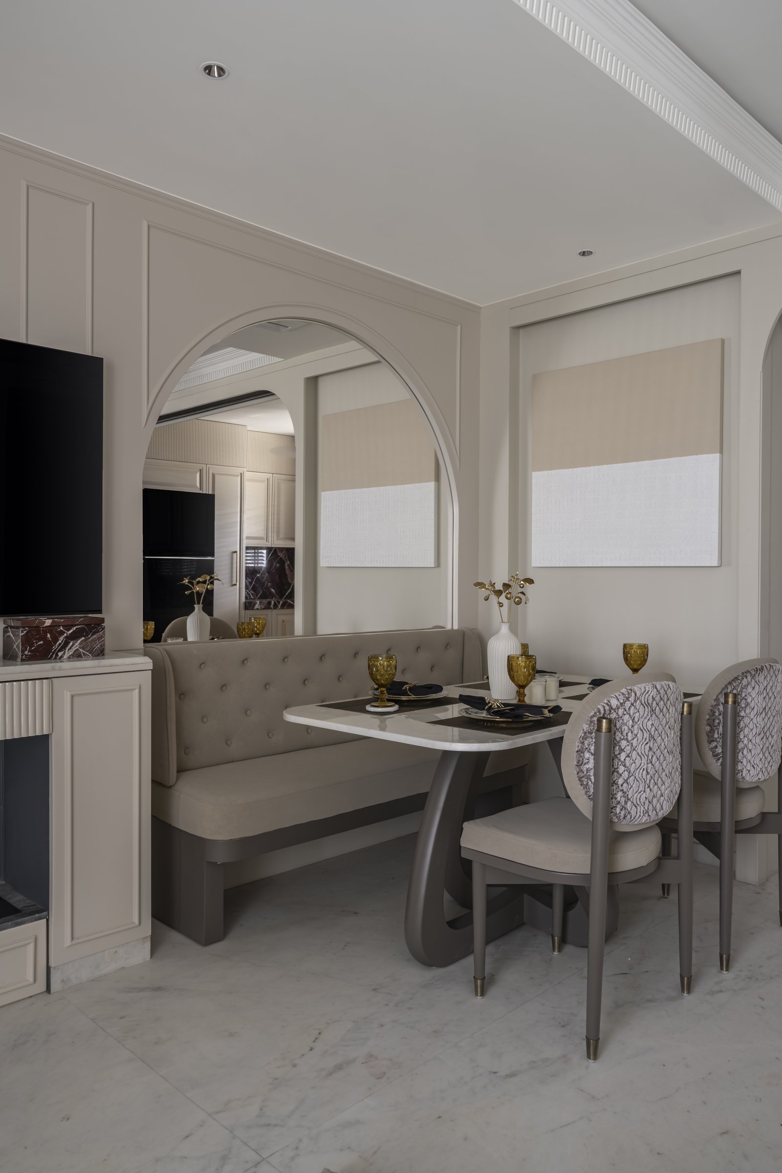 The arched alcove dining setting, with a tufted banquette and oval-backed chairs around a pedestal table