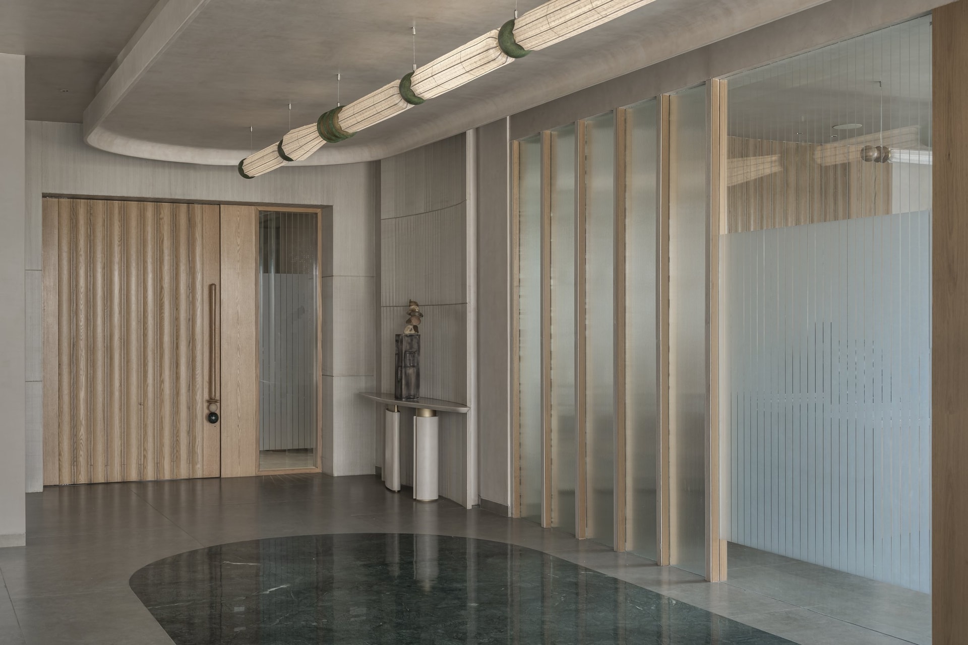 A wider view of the foyer, with reeded glass partitions filtering light from the office interior