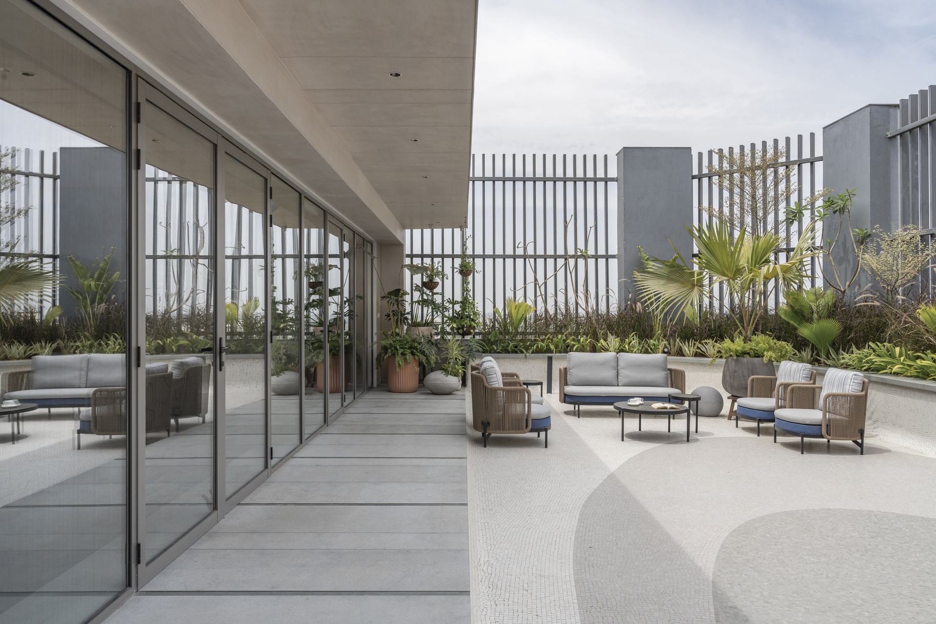 The terrace balcony, where woven outdoor seating sits beside a mosaic-paved floor