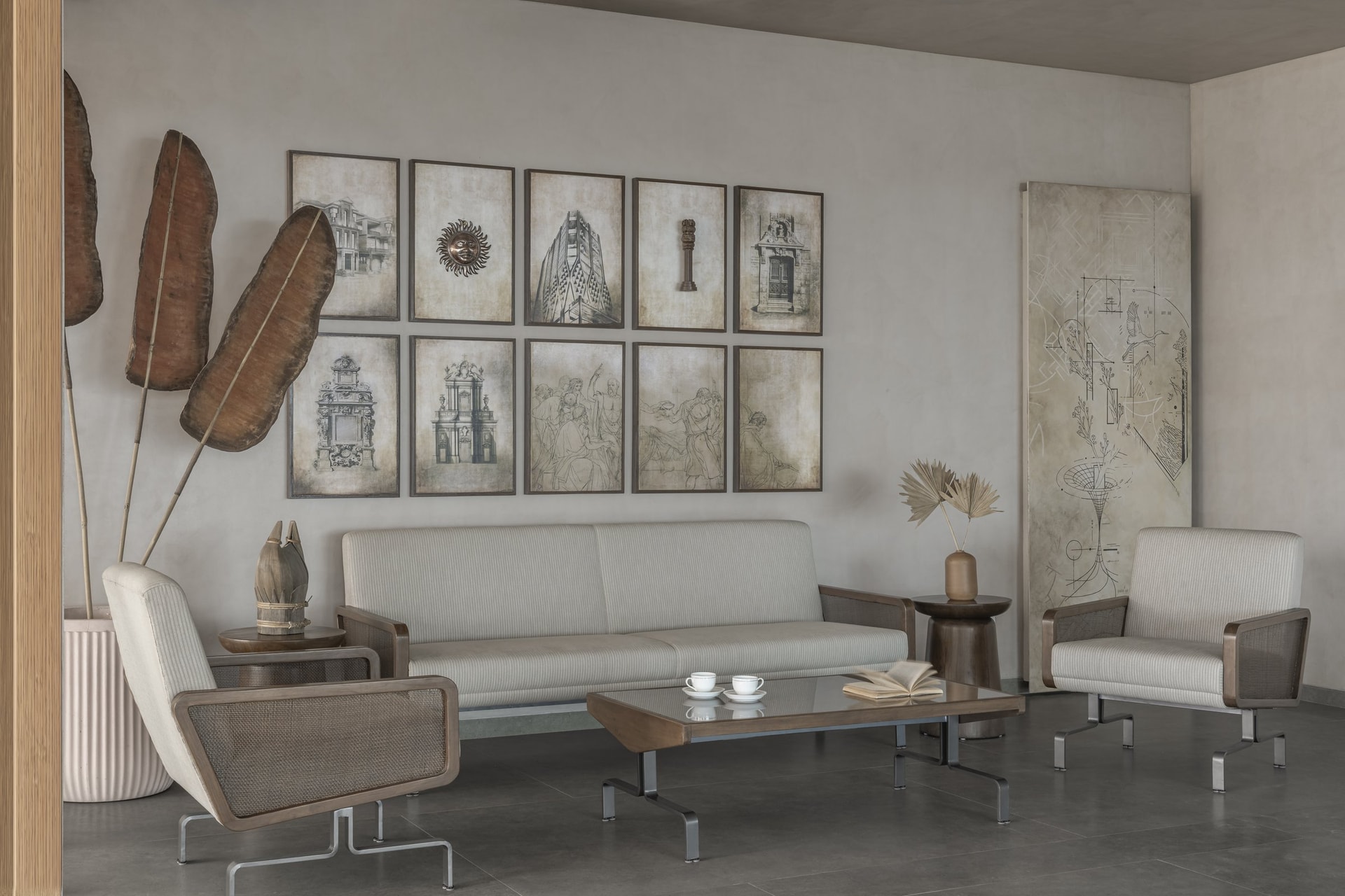The waiting lounge, where cane-backed seating and a layered gallery wall establish an understated collector's atmosphere